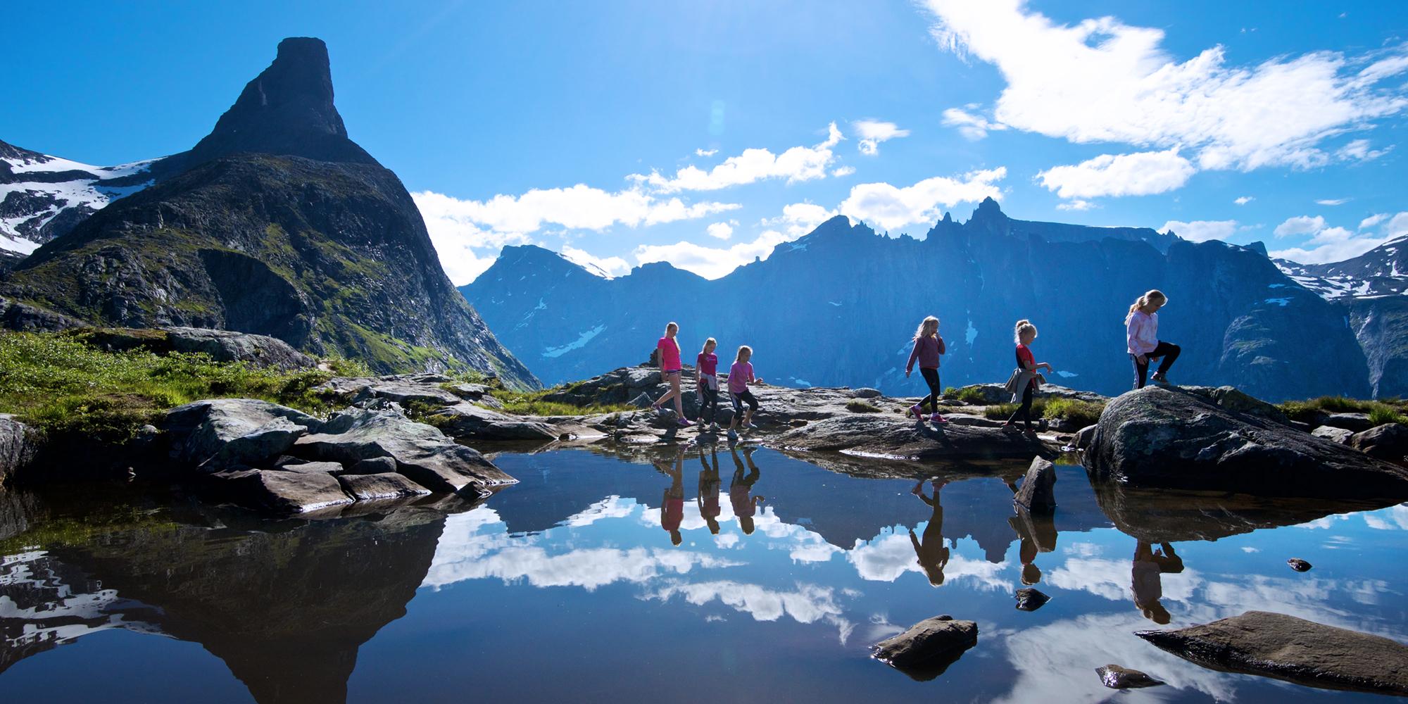 Flere mennesker vandrer på solfylte Litlefjellet i Romsdal.