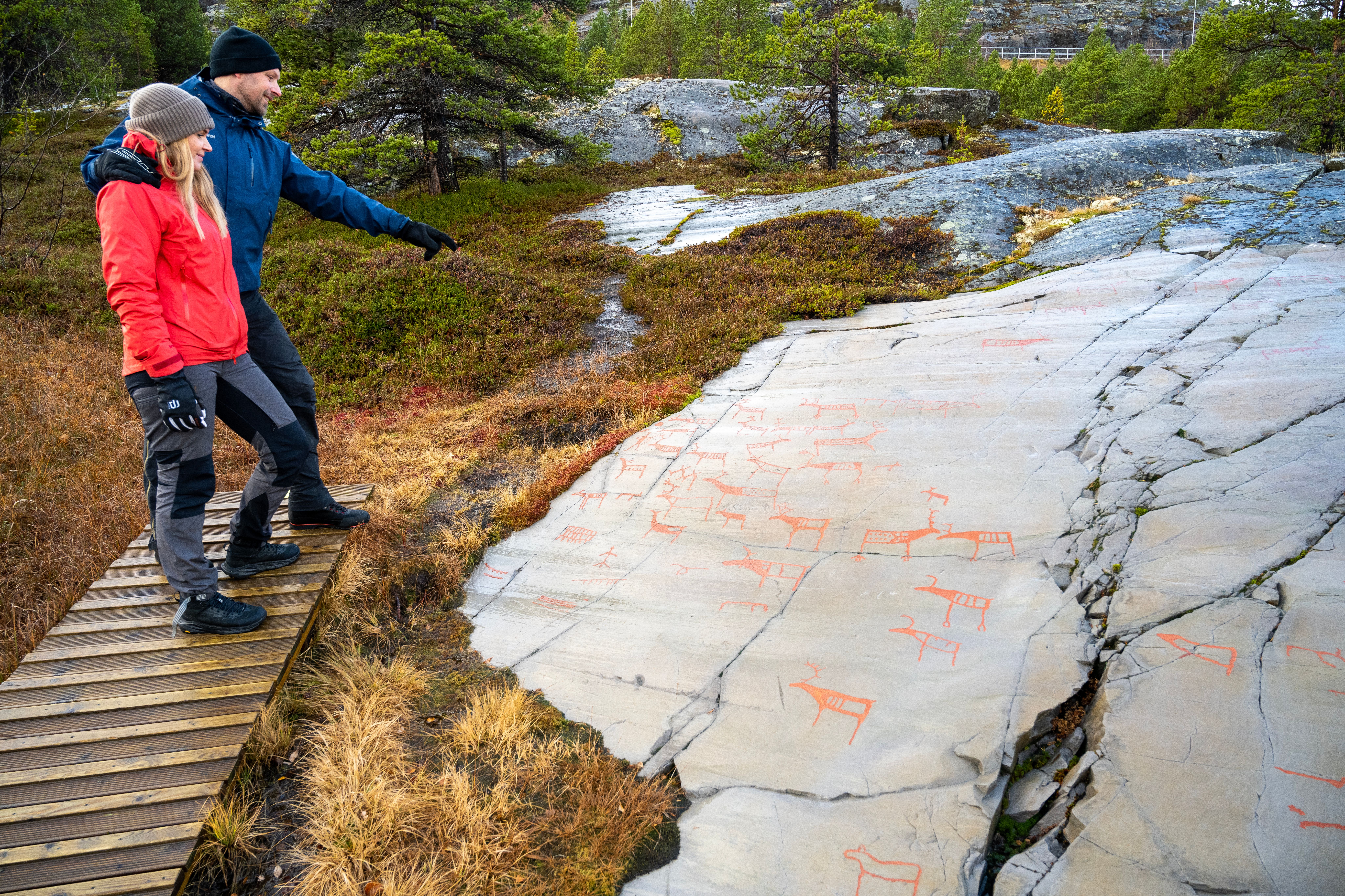 People looking at ancient rock carvings.