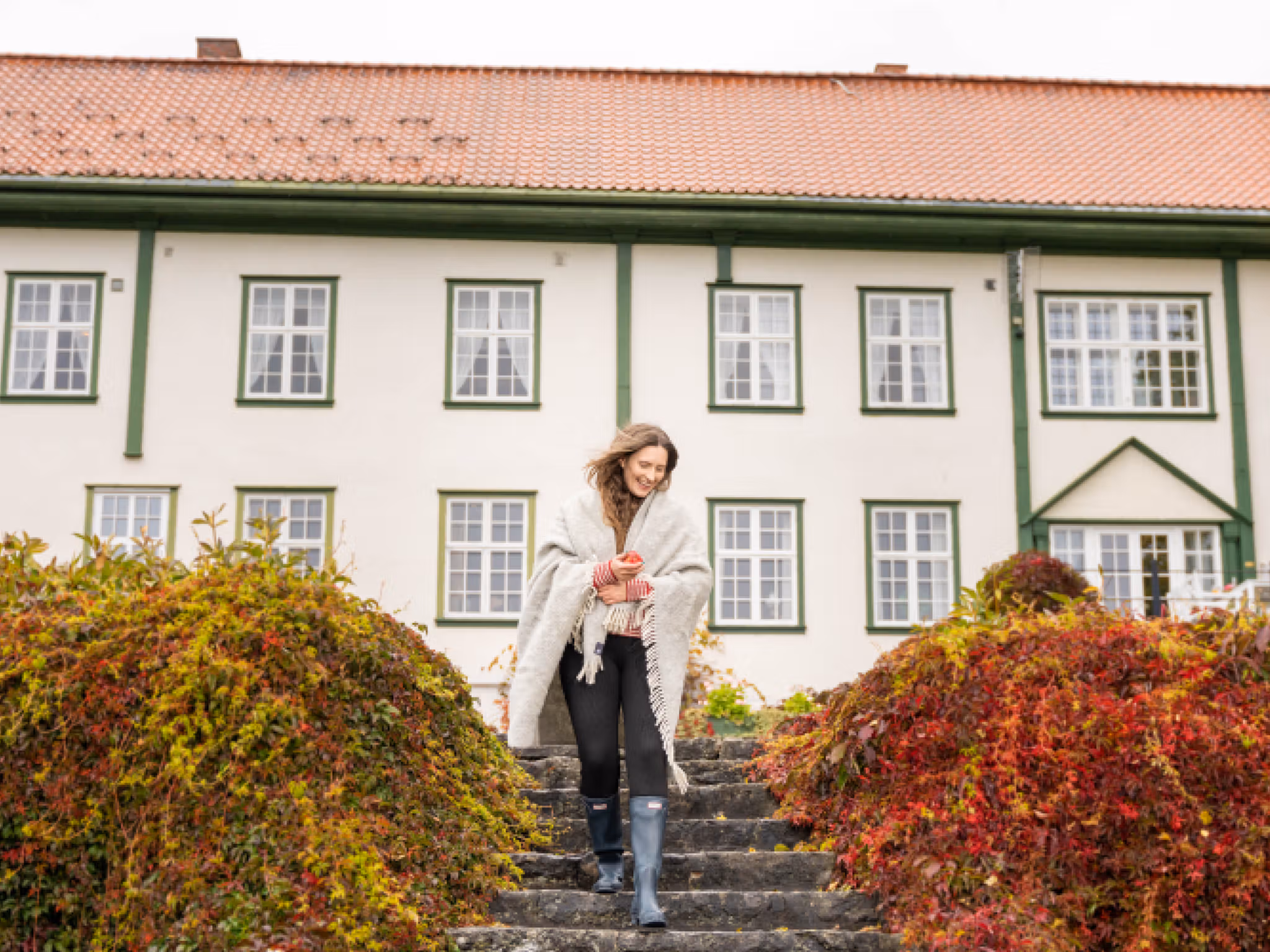 A woman goes for a stroll in the garden at Hoel Farm, Eastern Norway.
