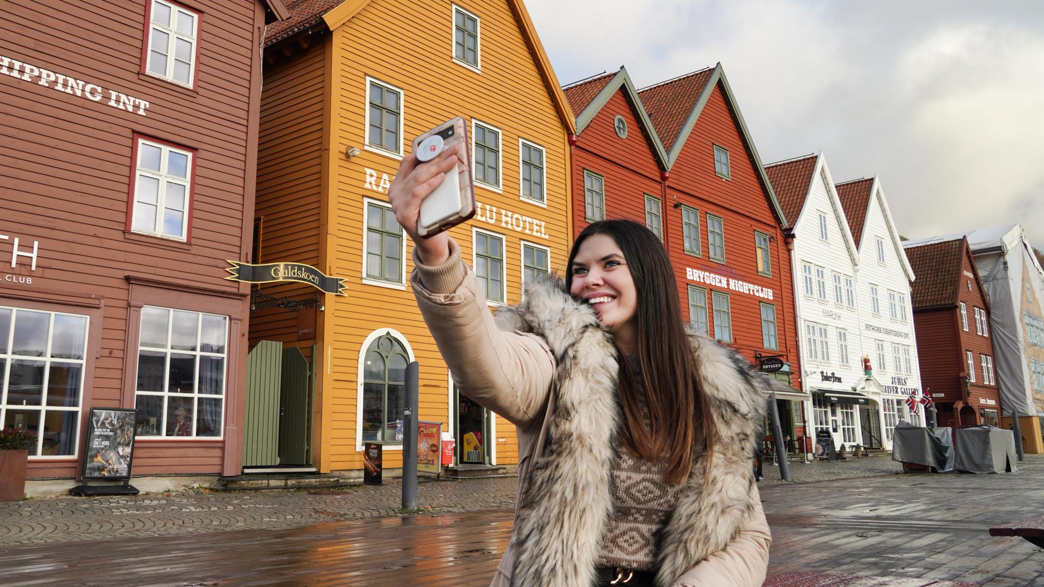 Jente som tar en selfie på Bryggen i Bergen