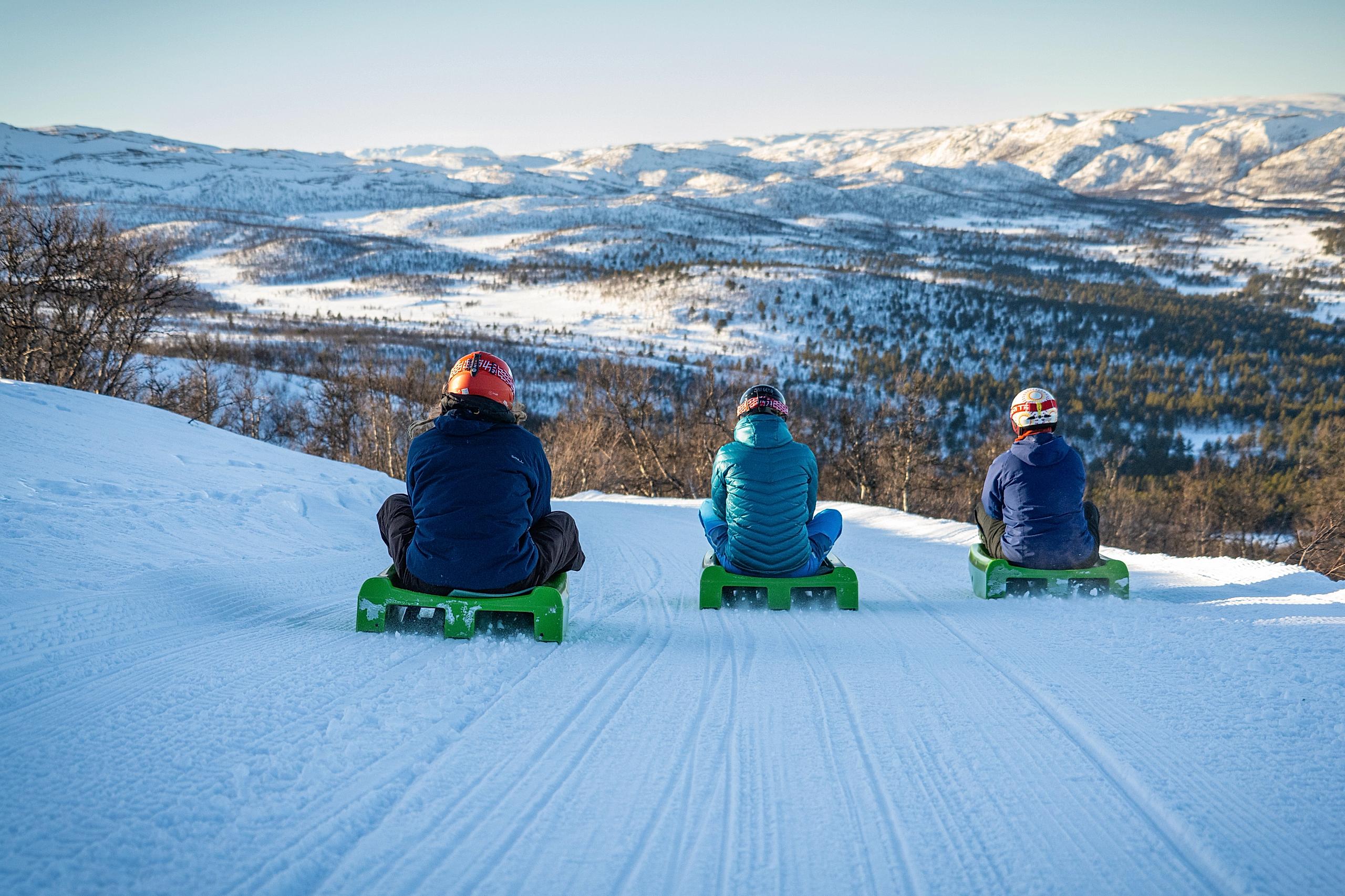 Friends going tobogganing at Dagali Fjellpark, Eastern Norway.