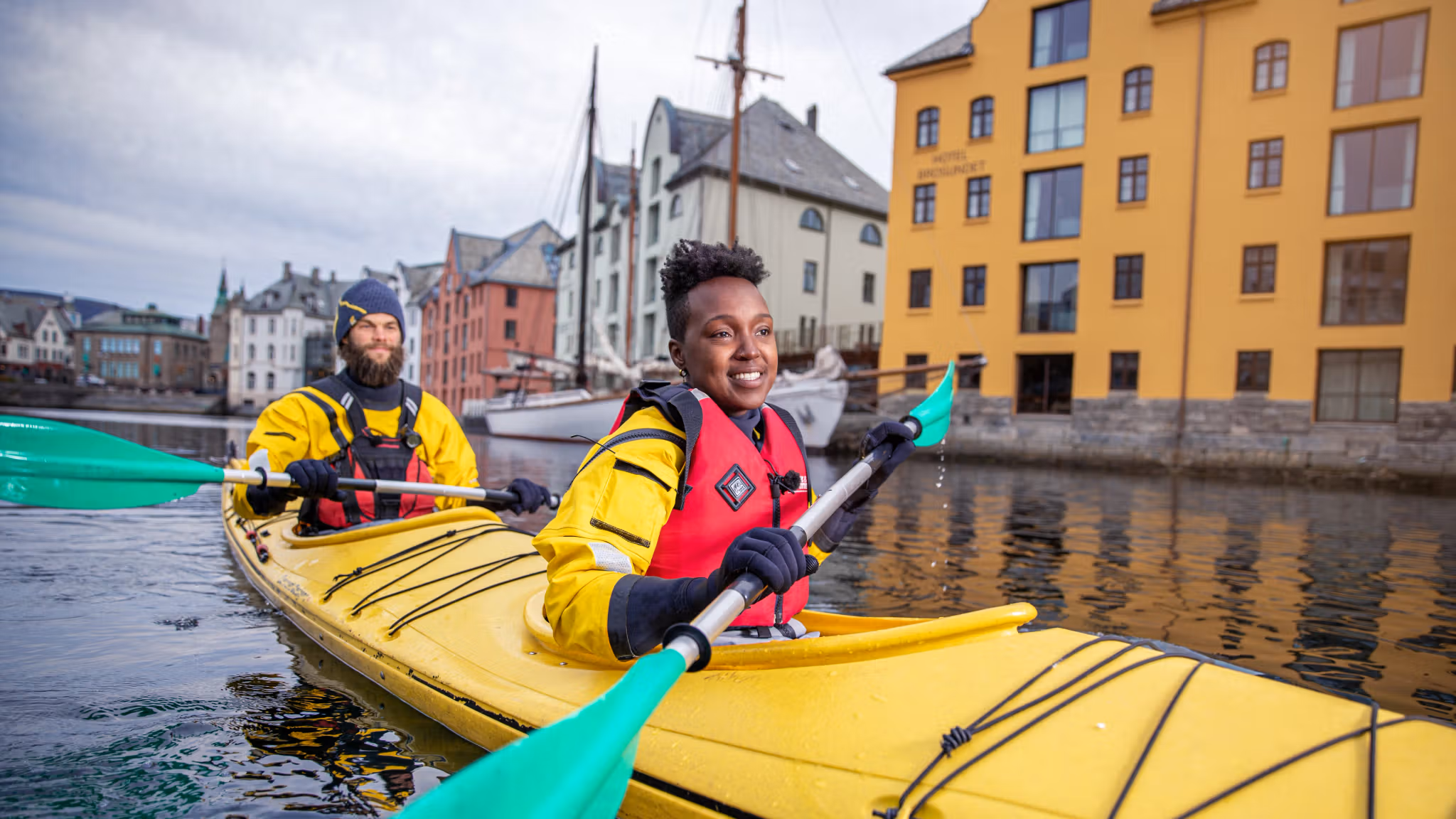 Två personer paddlar kajak i Ålesund i regionen Fjord Norge (Vestlandet)