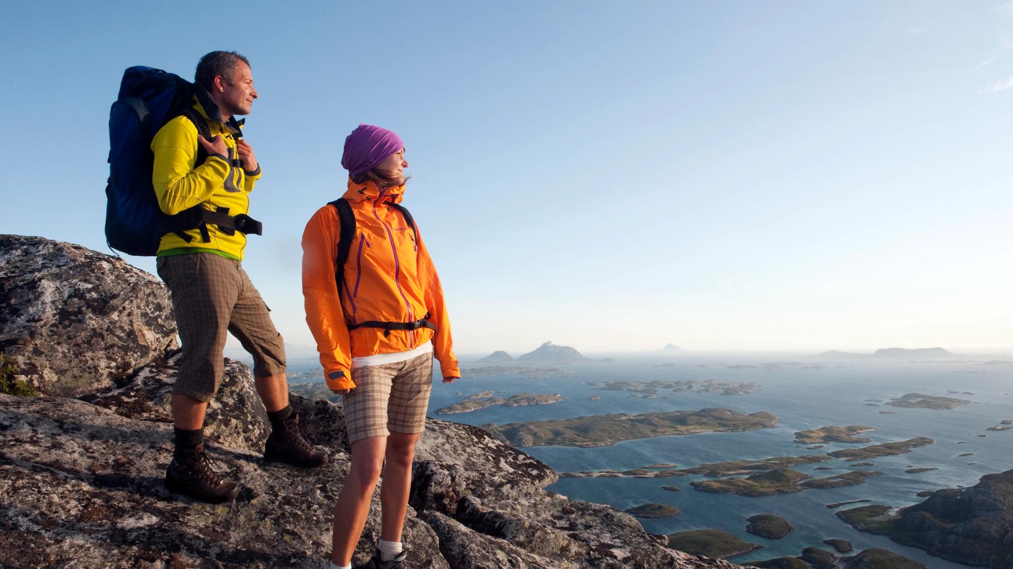 Dos personas hacen senderismo por las montañas del litoral de Helgeland, en el Norte de Noruega.