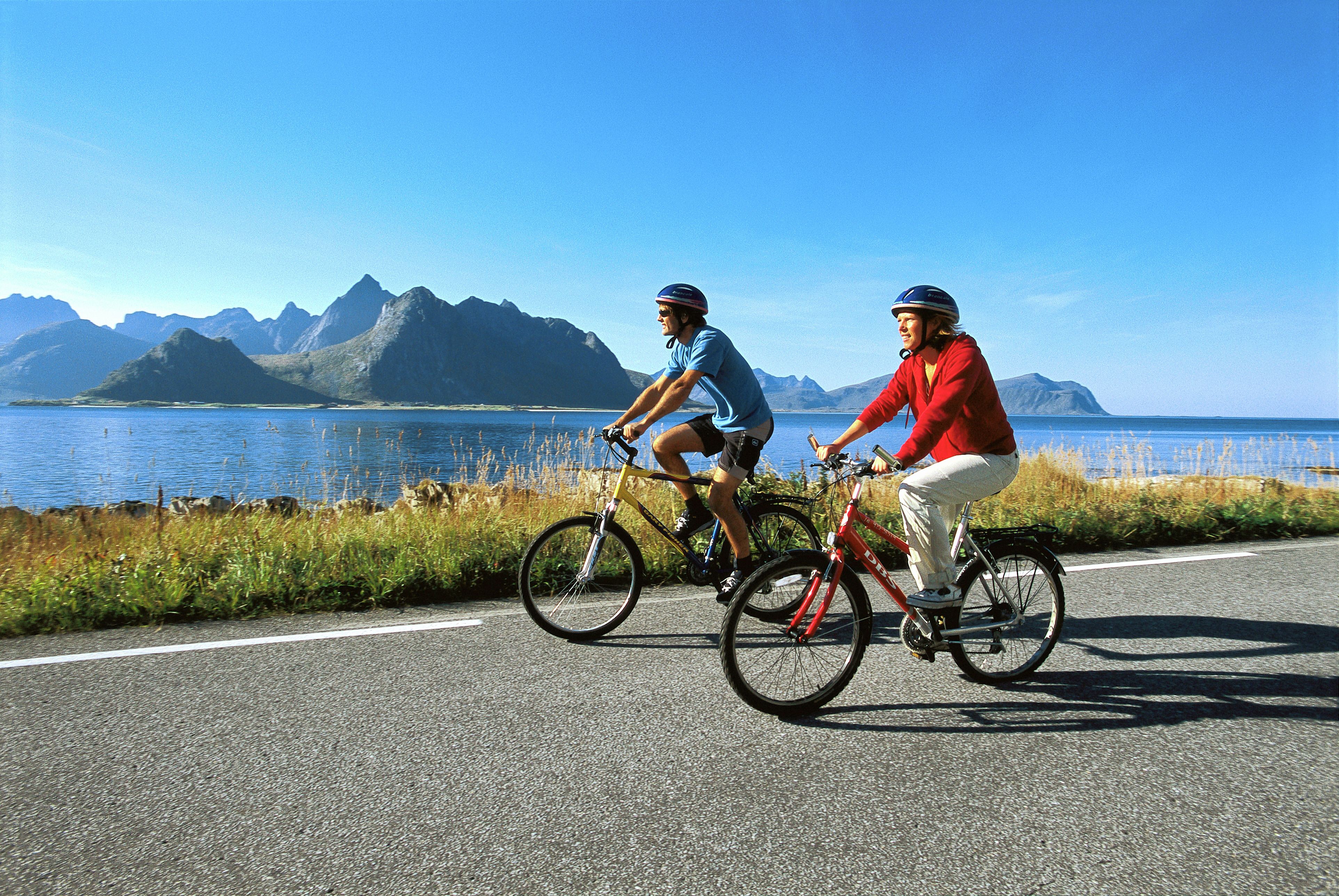 Two people cycling along the coast of Lofoten in Northern Norway