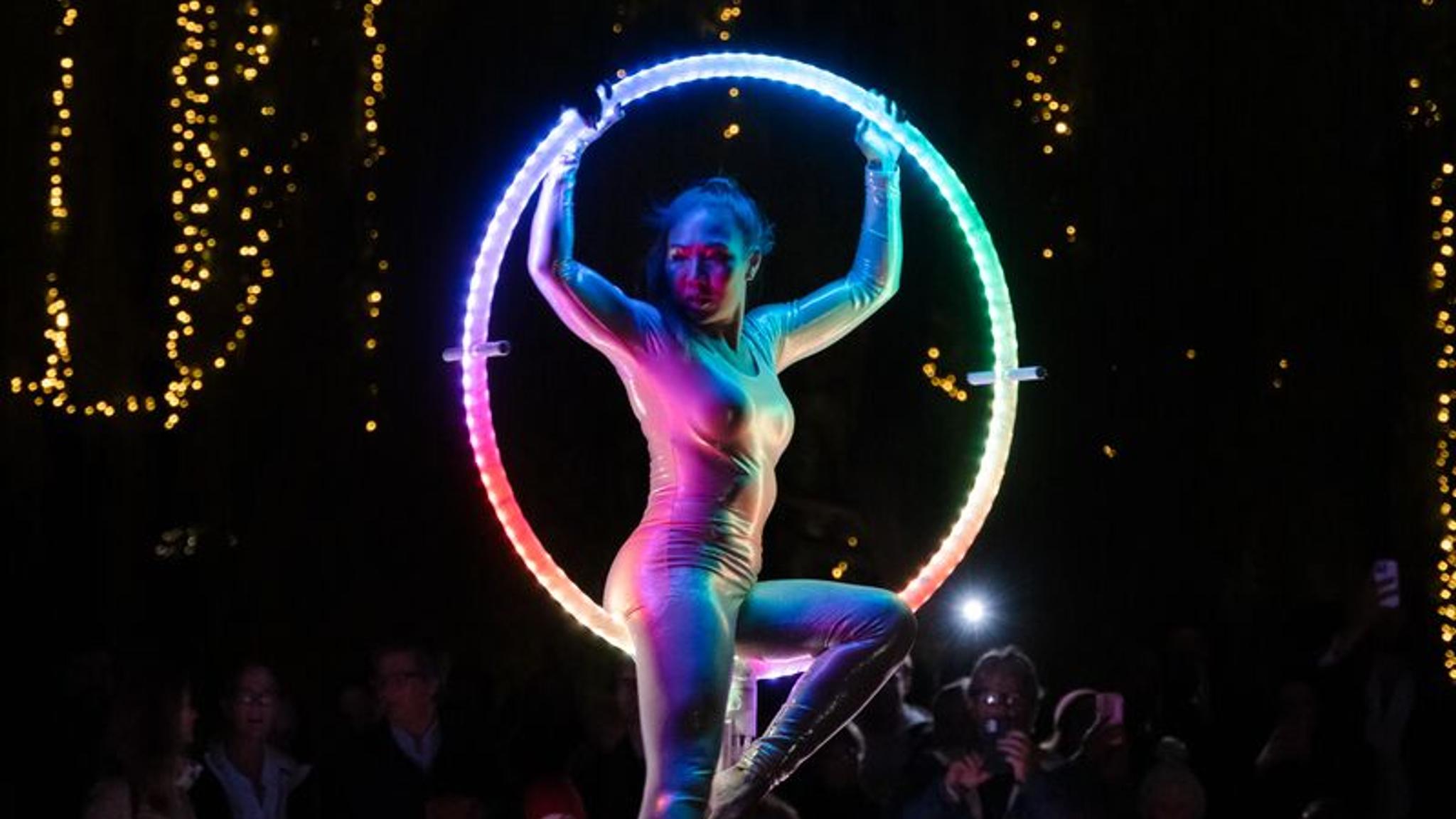 En kvinne gjør ringakrobatikk under Elvelangs lysfestival i Oslo