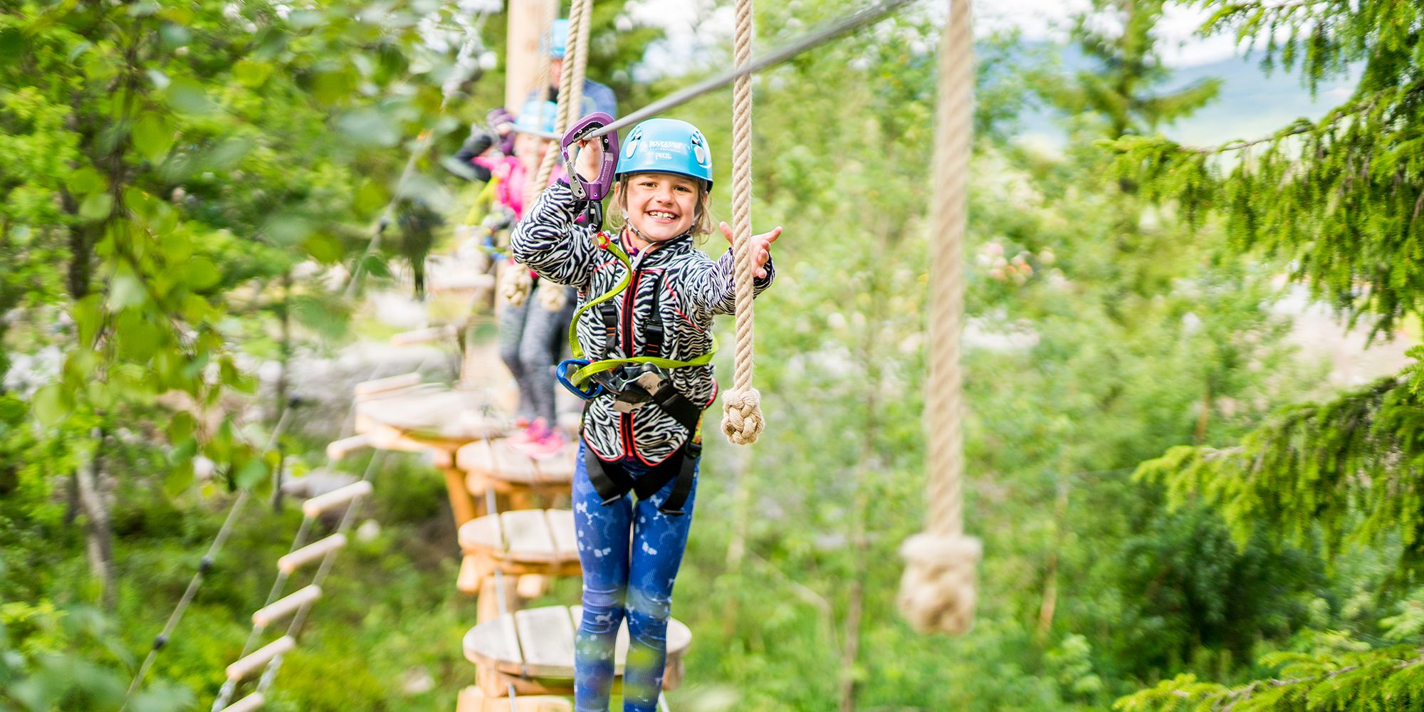 En jente på familieferie i Trysil på Østlandet, i klatreparken Høyt & Lavt