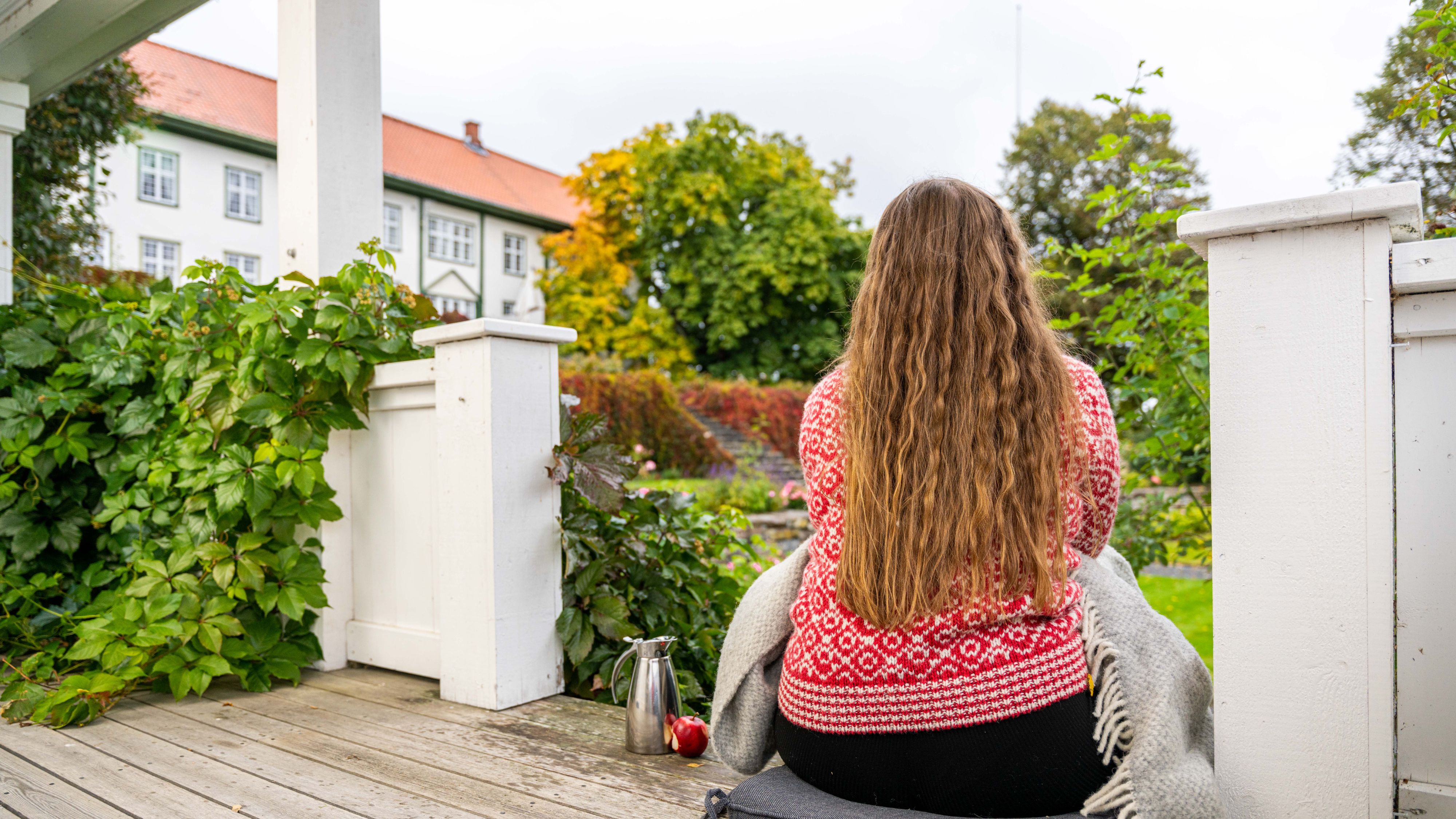 En kvinne nyter utsikten over hagen til Hoel Gård, Østlandet, Norge.