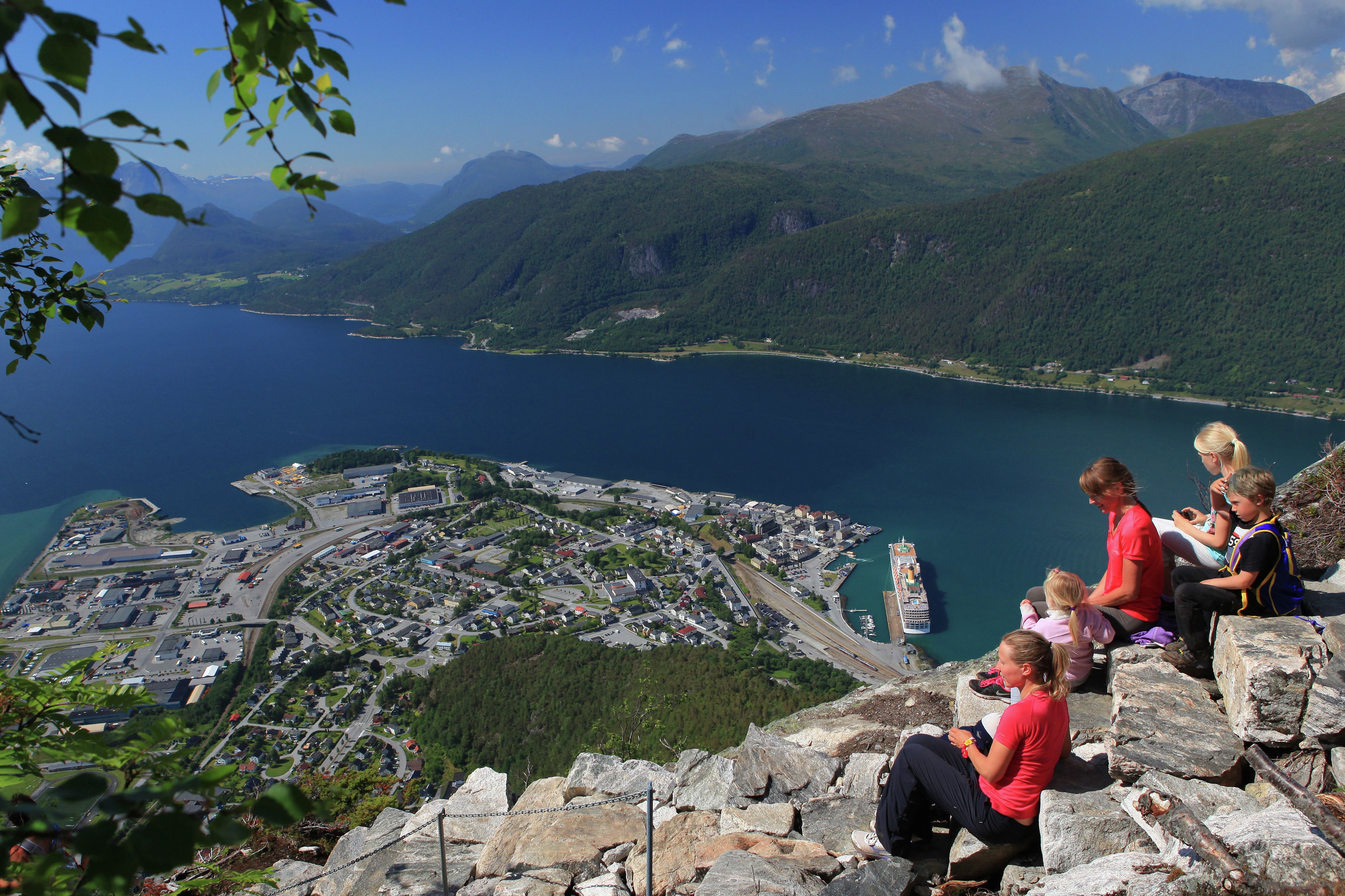 En gruppe mennesker nyter utsikten over Åndalsnes fra toppen av Romsdalstrappa i Nordvest på Vestlandet.