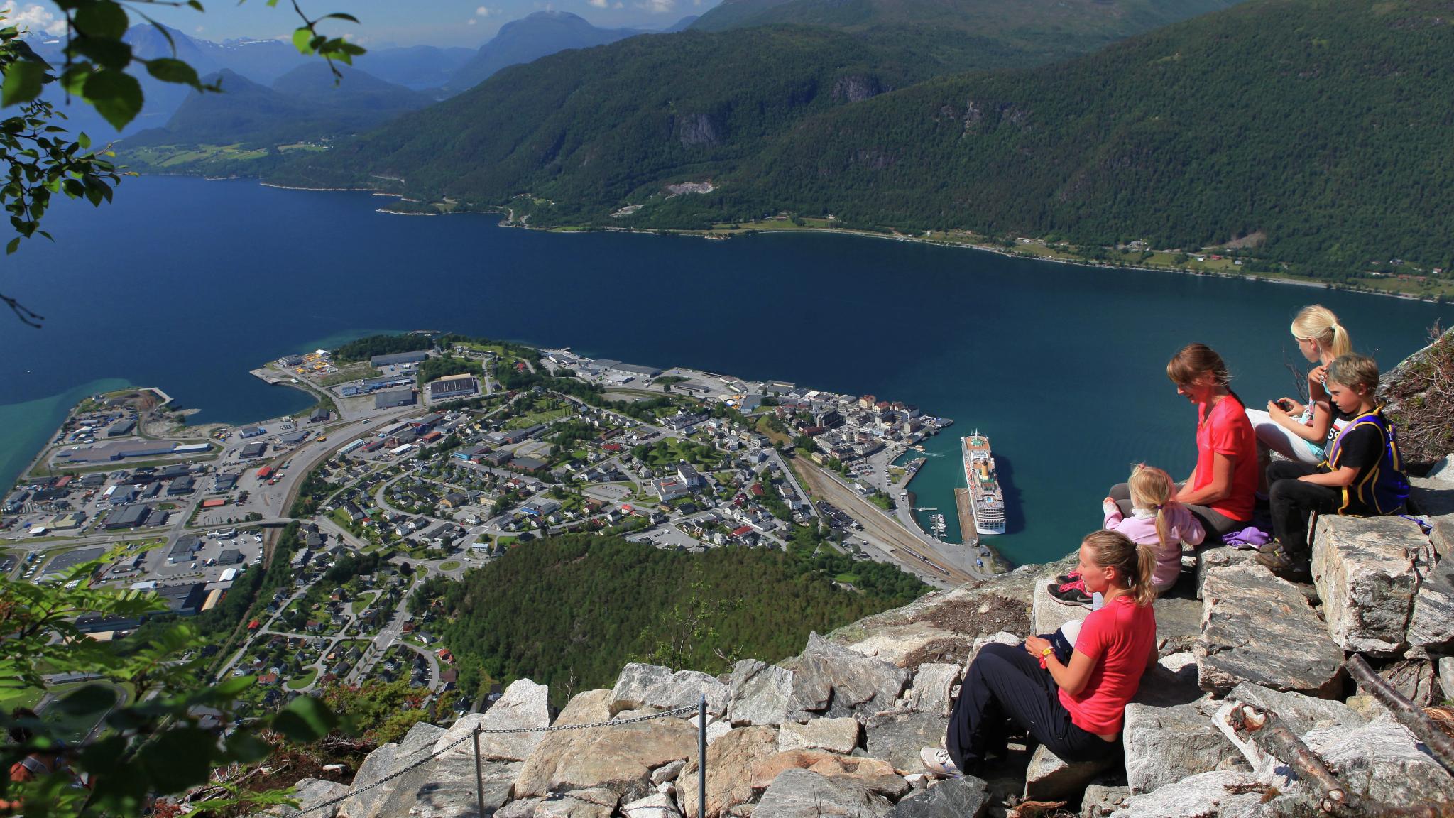 En gruppe mennesker nyter utsikten over Åndalsnes fra toppen av Romsdalstrappa i Nordvest på Vestlandet.