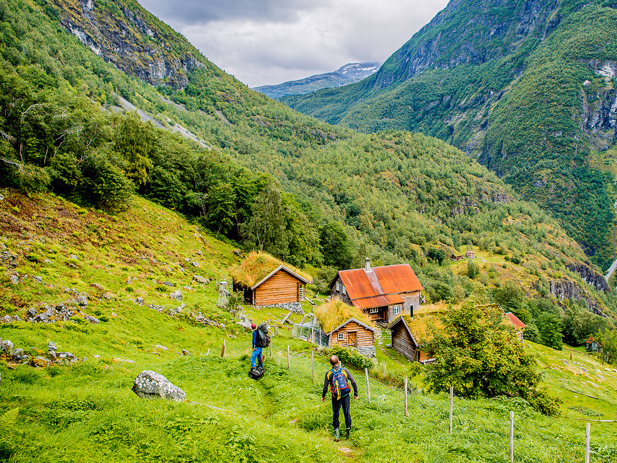 Dos personas caminan hacia las instalaciones de la granja de montaña Avdalen Gard, en el valle de Utladalen, la Noruega de los fiordos.