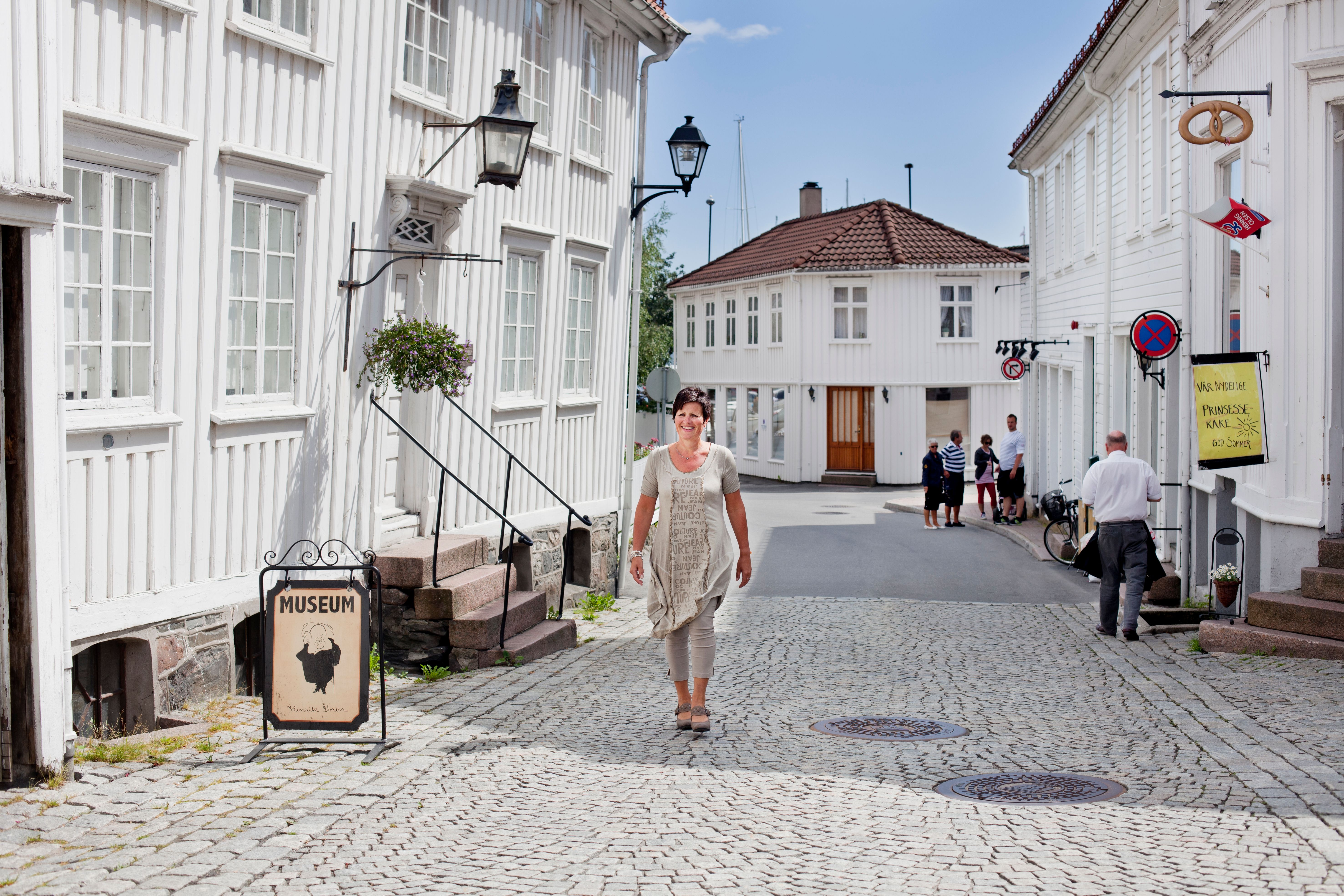 En dame går forbi Ibsen-museet i Grimstad