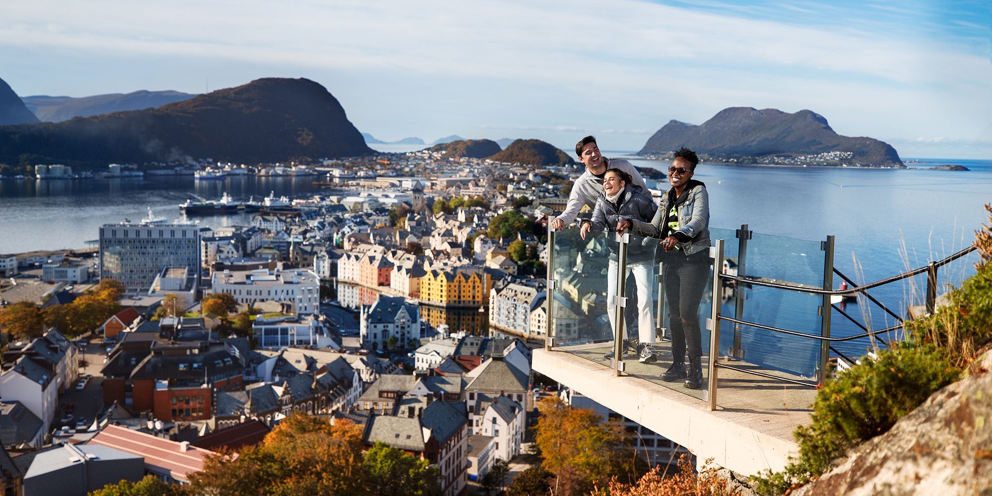 Drei Personen auf einer Aussichtsplattform am Berg Aksla in Ålesund, Fjord Norwegen