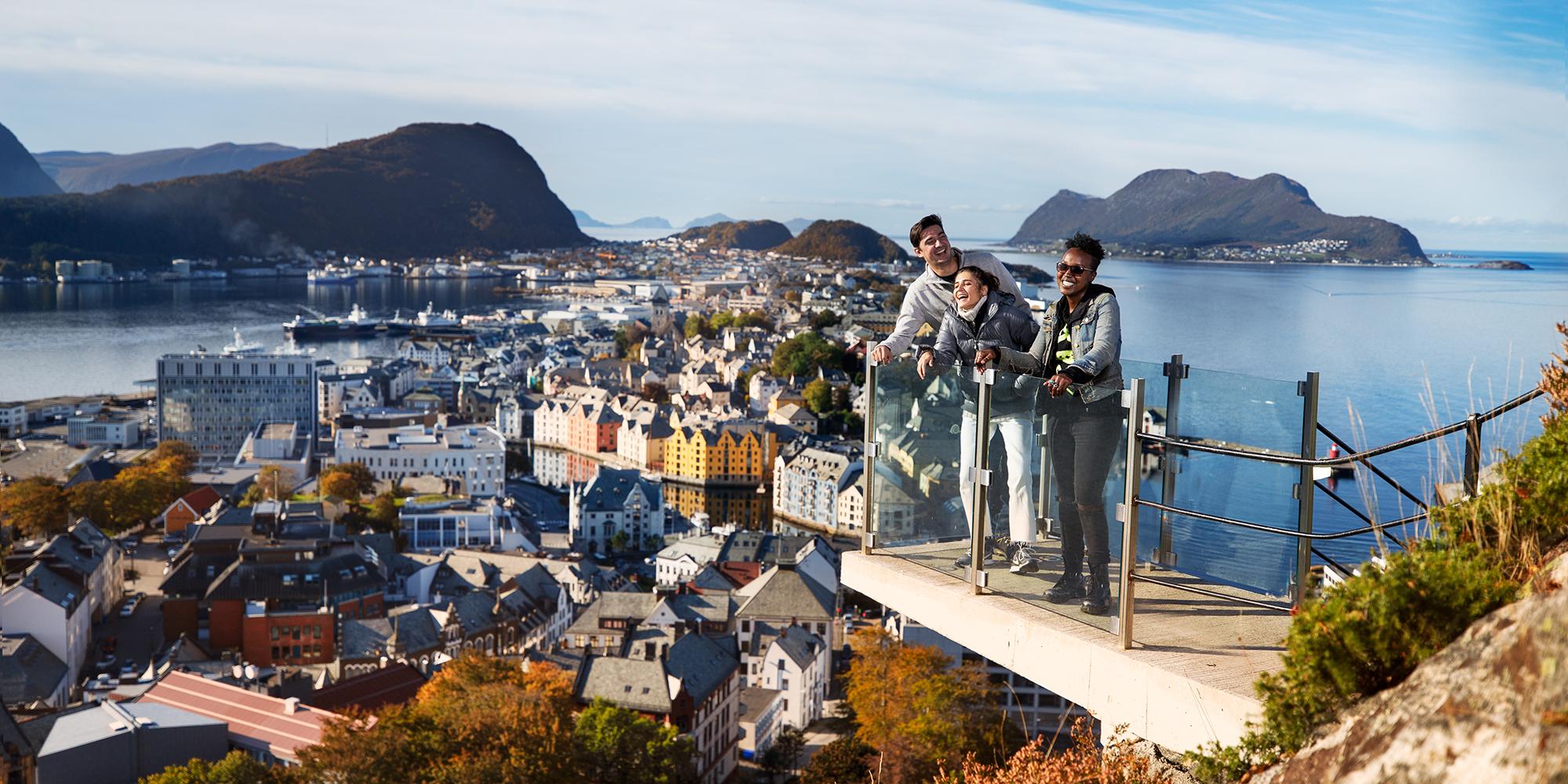 Drei Personen auf einer Aussichtsplattform am Berg Aksla in Ålesund, Fjord Norwegen