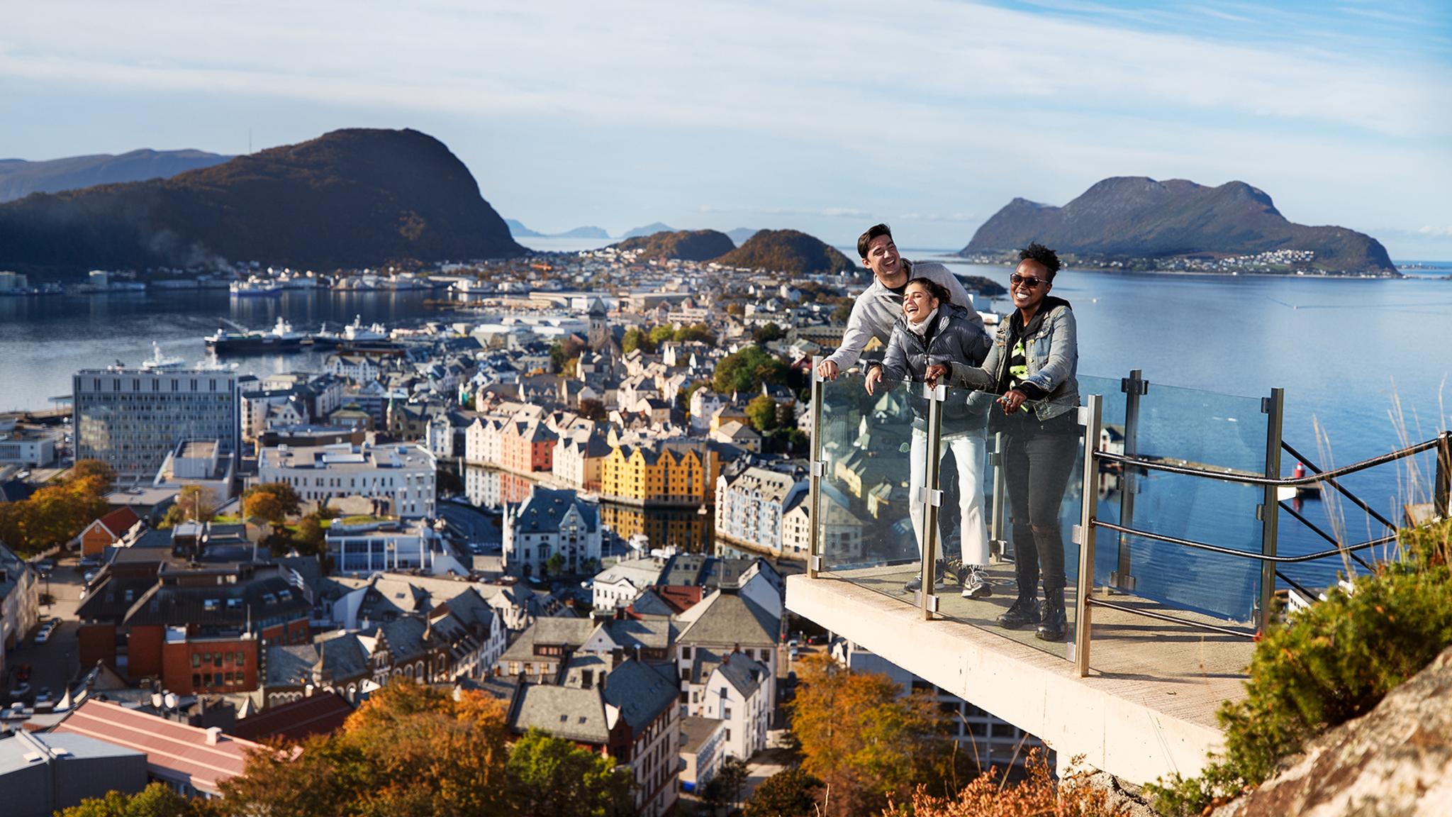 Drei Personen auf einer Aussichtsplattform am Berg Aksla in Ålesund, Fjord Norwegen