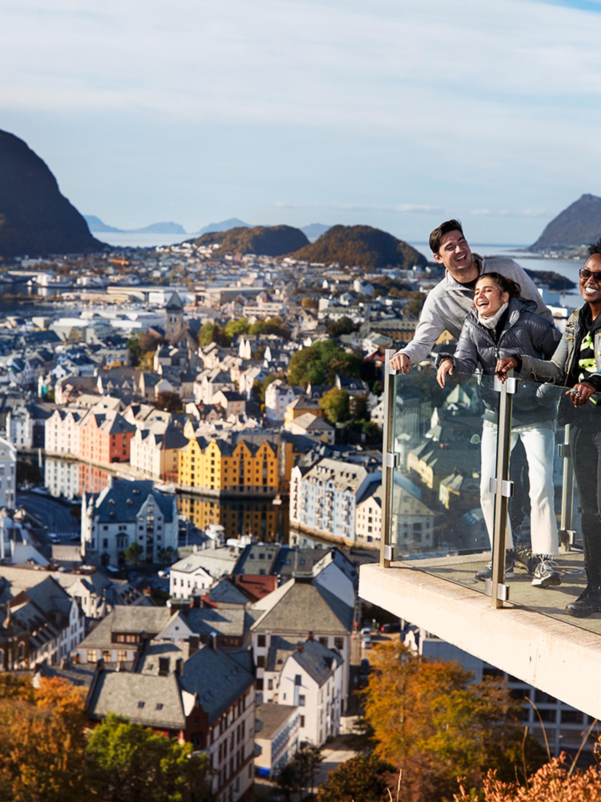 Tre personer står vid utsiktsplatsen Aksla i Ålesund, Fjord Norge (Vestlandet)
