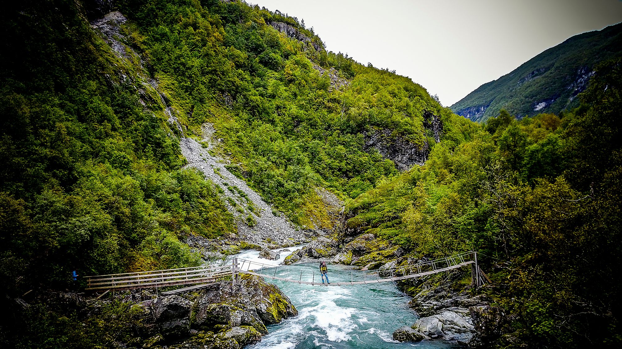 En man går över en bro i Utladalen i Fjord Norge