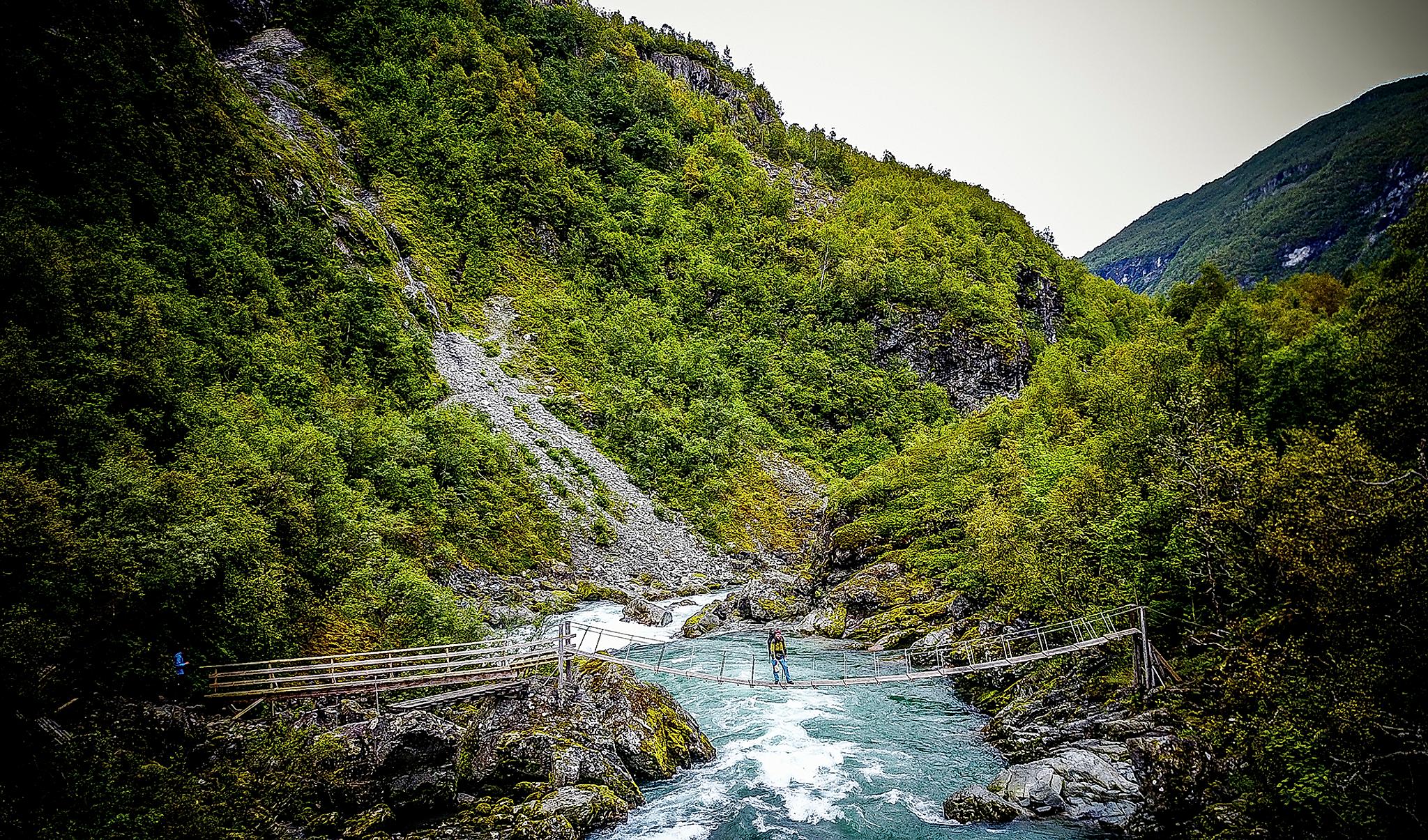 En man går över en bro i Utladalen i Fjord Norge