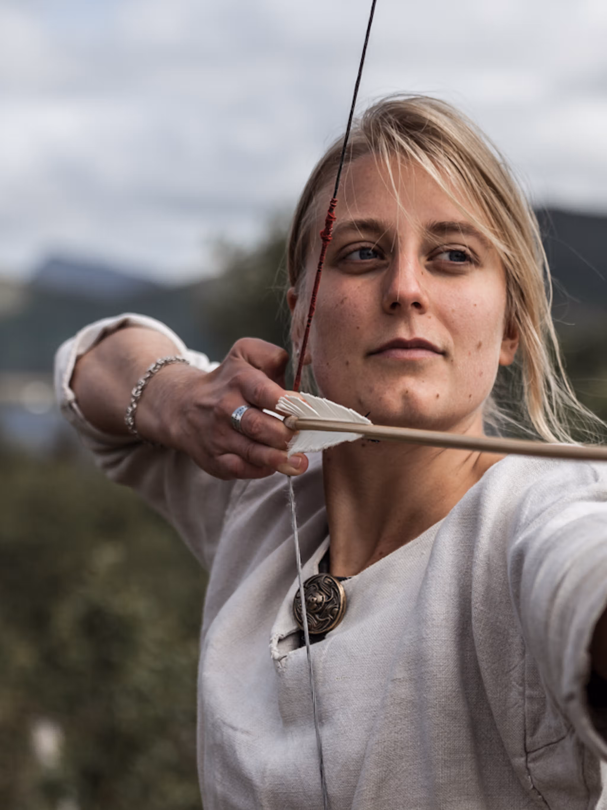 Woman shooting with a bow and arrow at the Lofotr Viking Museum
