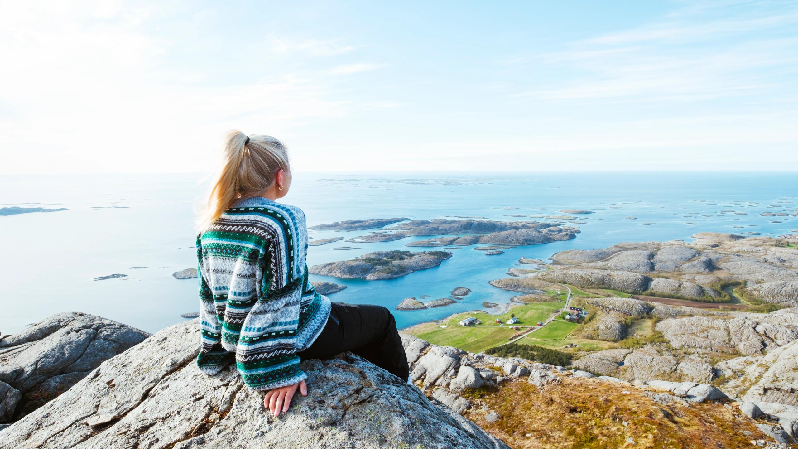 A woman enjoying the view from the top of a mountain.