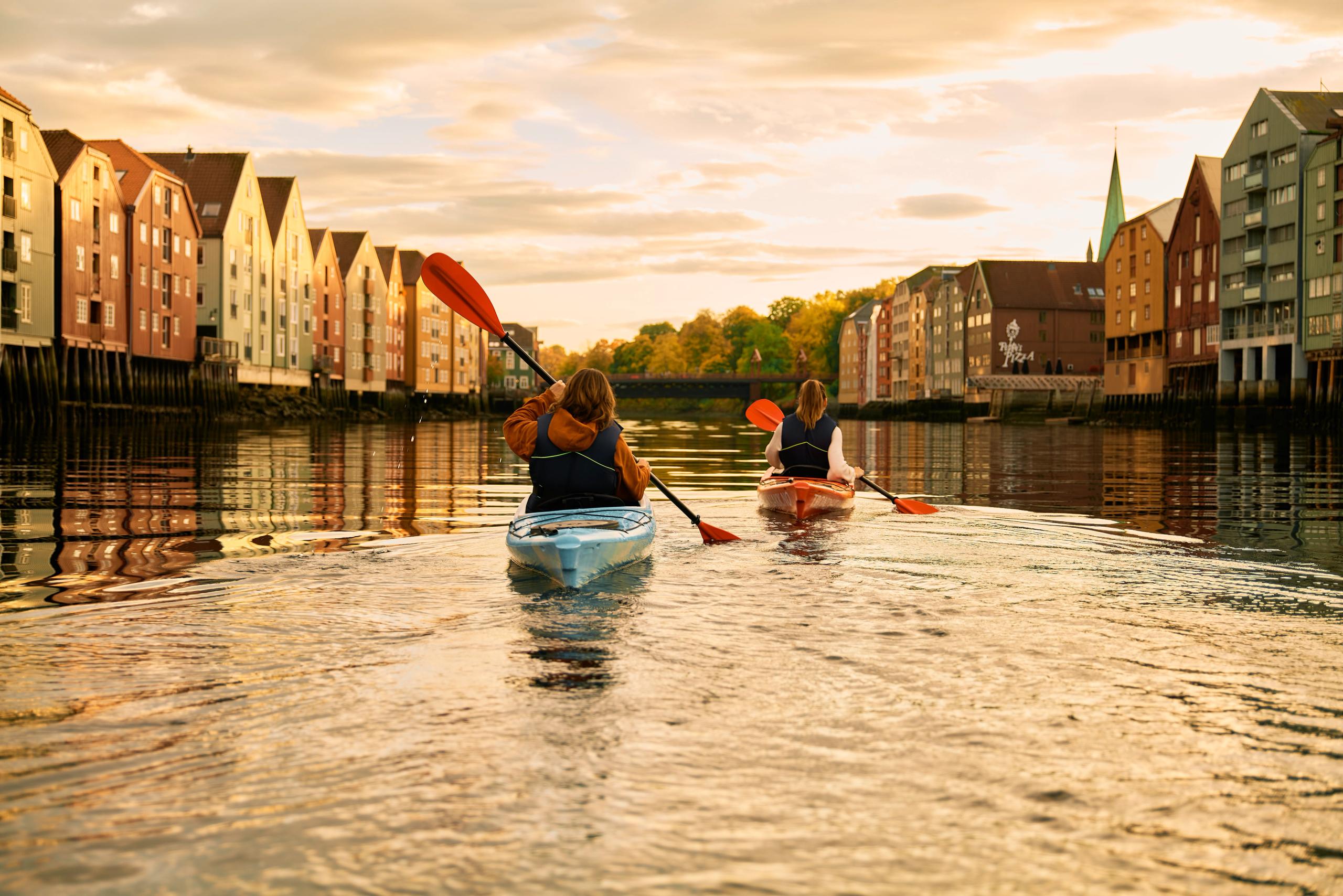 To personer padler i solnedgangen på Nidelva i Trondheim
