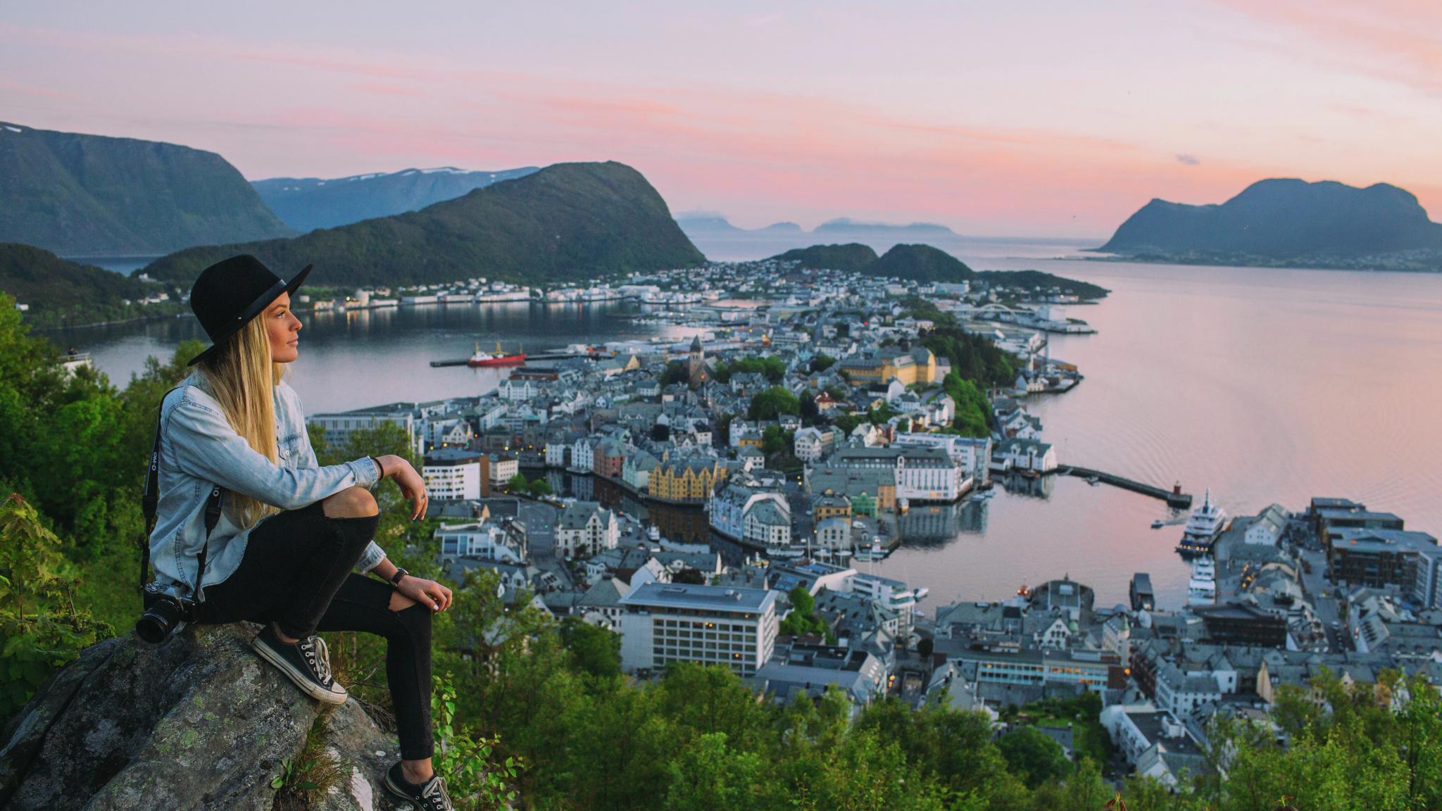 En dame sitter og skuer utover Ålesund fra Aksla utsiktspunkt