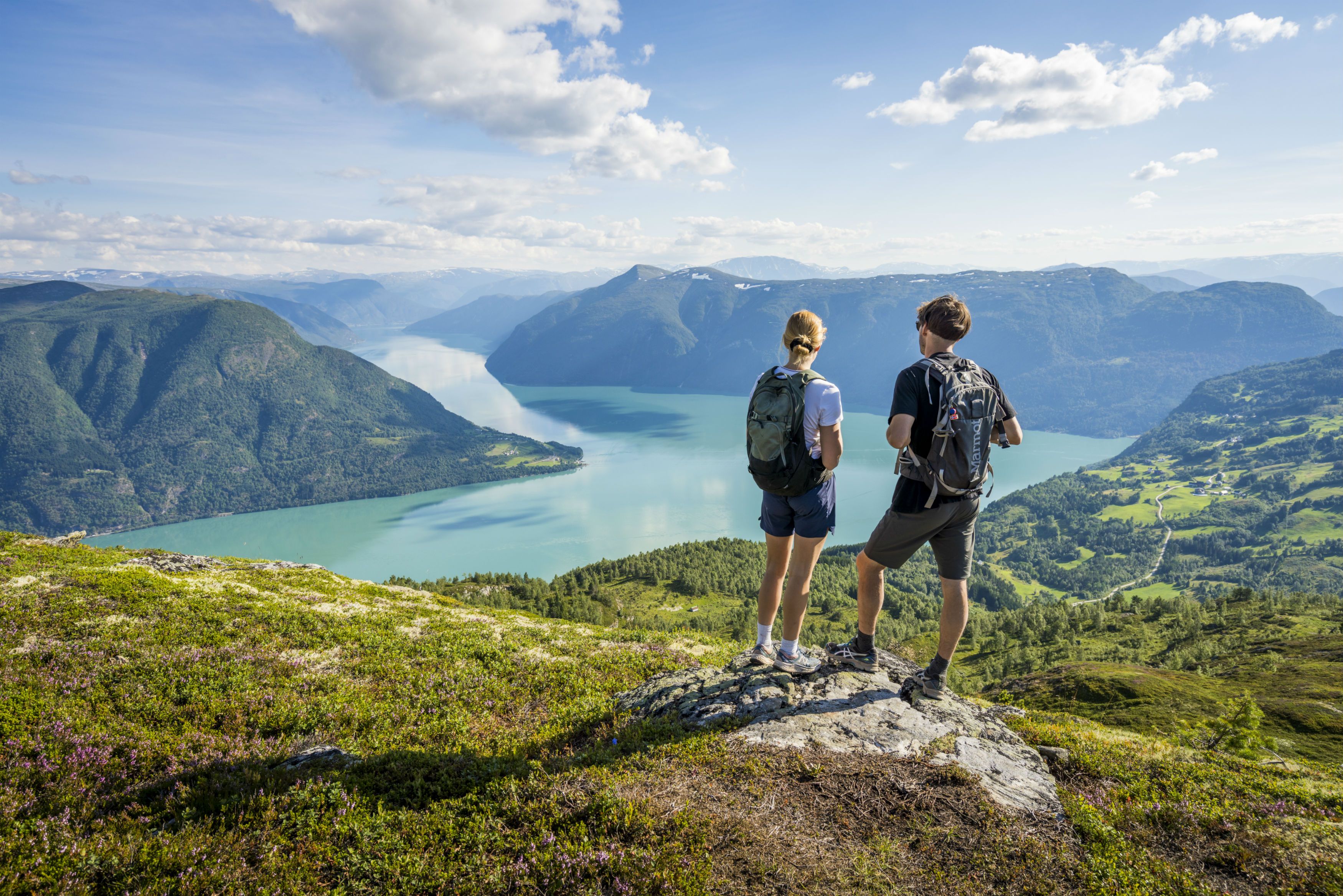 To personer nyter utsikten over fjorden fra Molden i Luster på Vestlandet