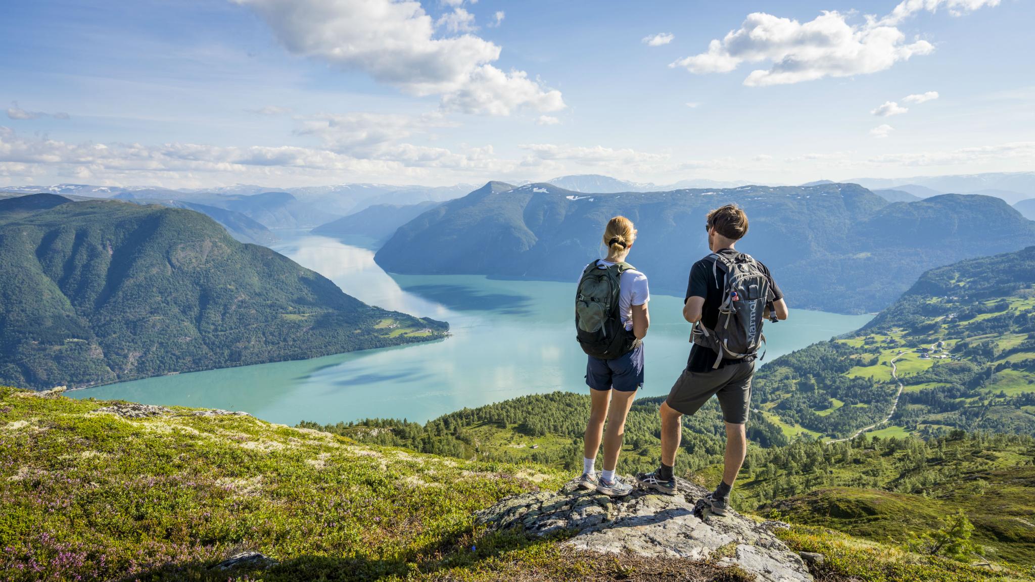 To personer nyter utsikten over fjorden fra Molden i Luster på Vestlandet