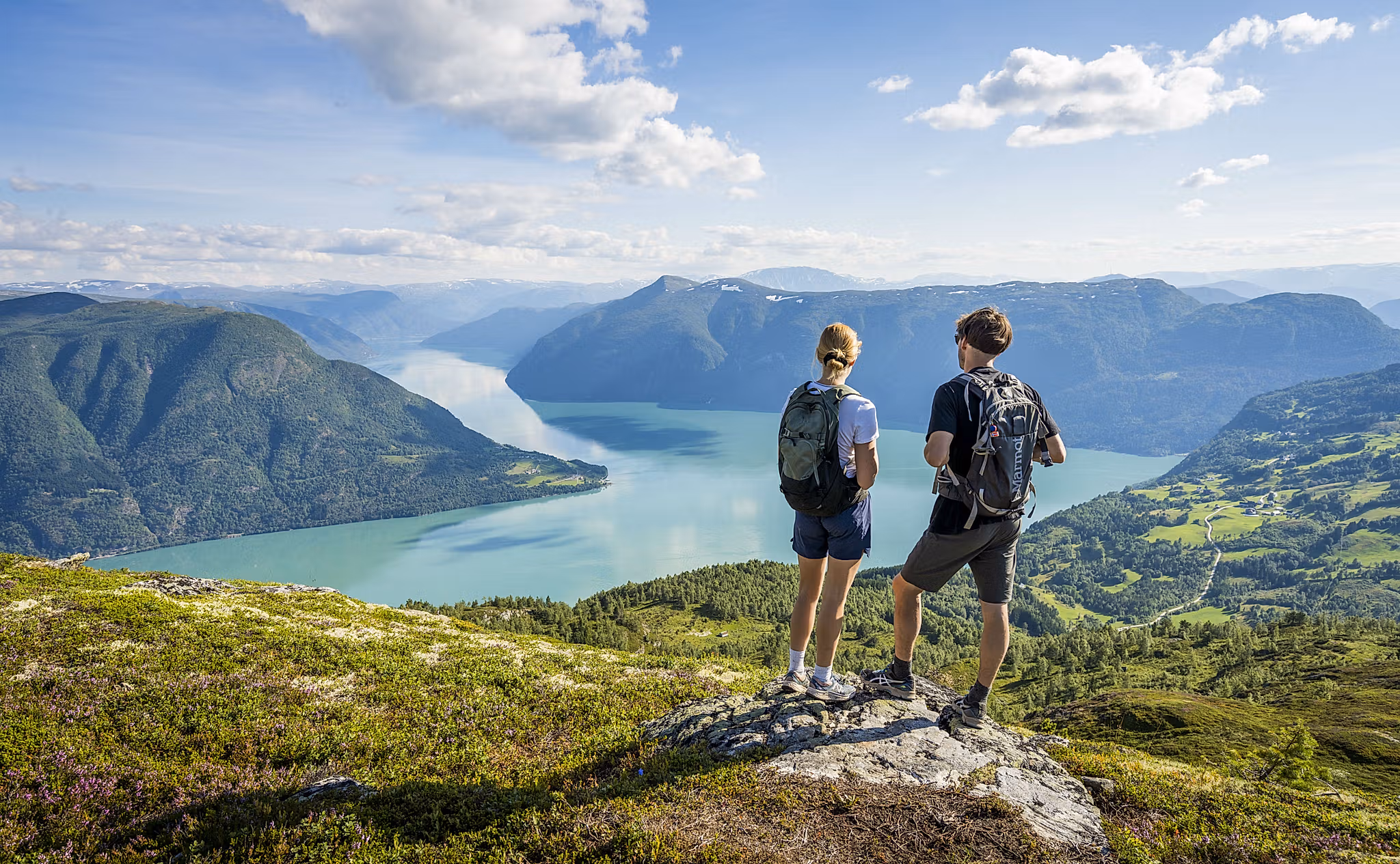 Two people admiring the view from the top of mount Molden in the Sognefjord area of Fjord Norway