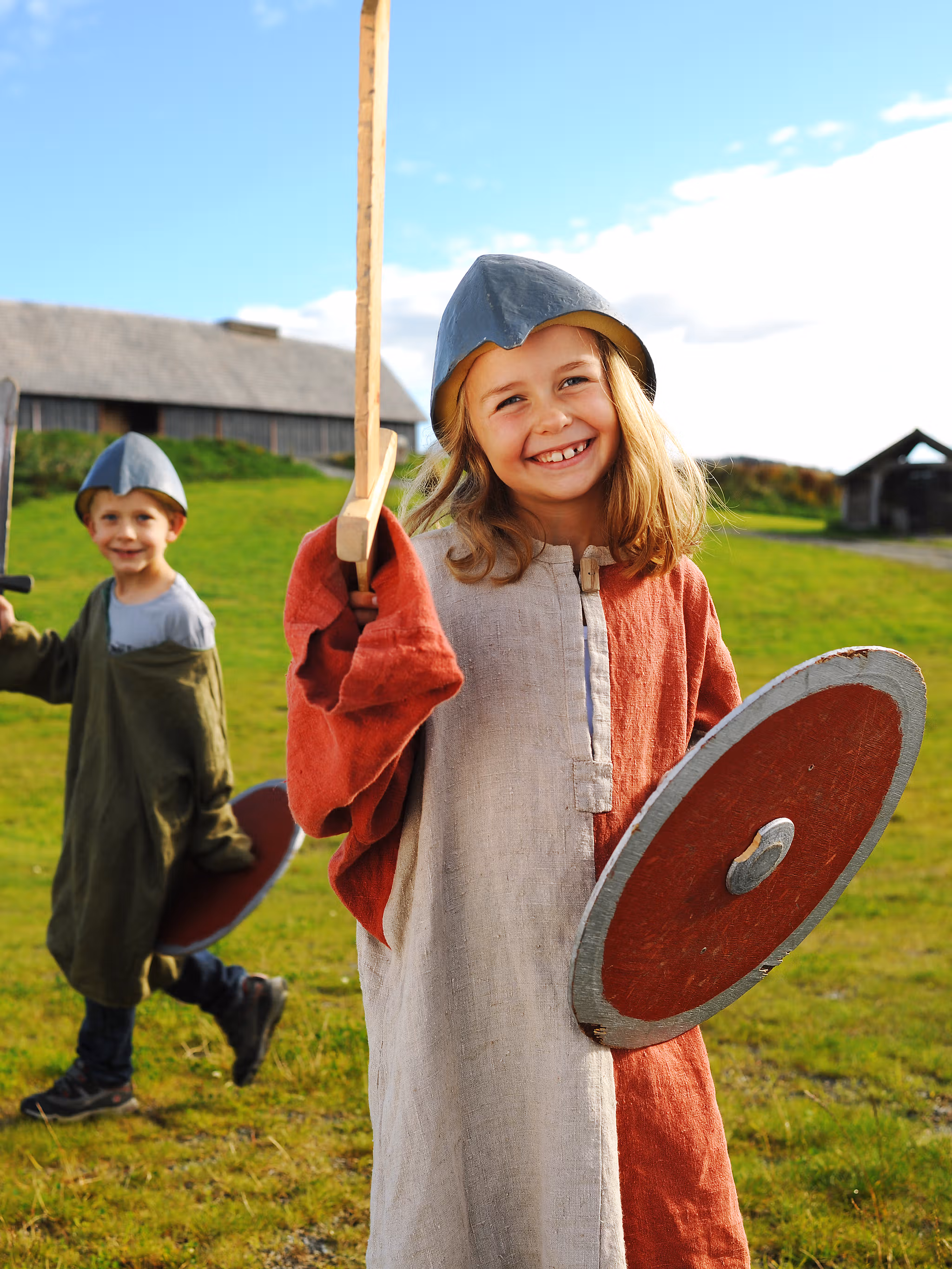 Children dressed as Vikings in front of a longhouse at Stiklestad in Trøndelag, Norway