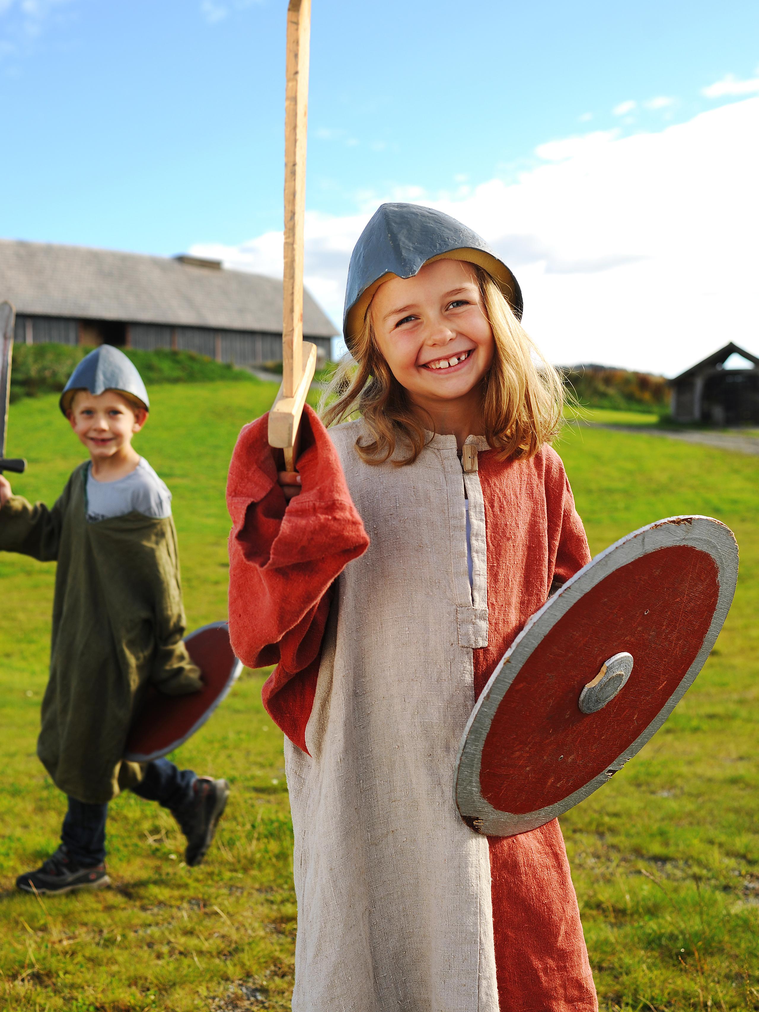 Barn uklädda till vikingar framför ett långhus på Stiklestad i Trøndelag, Norge
