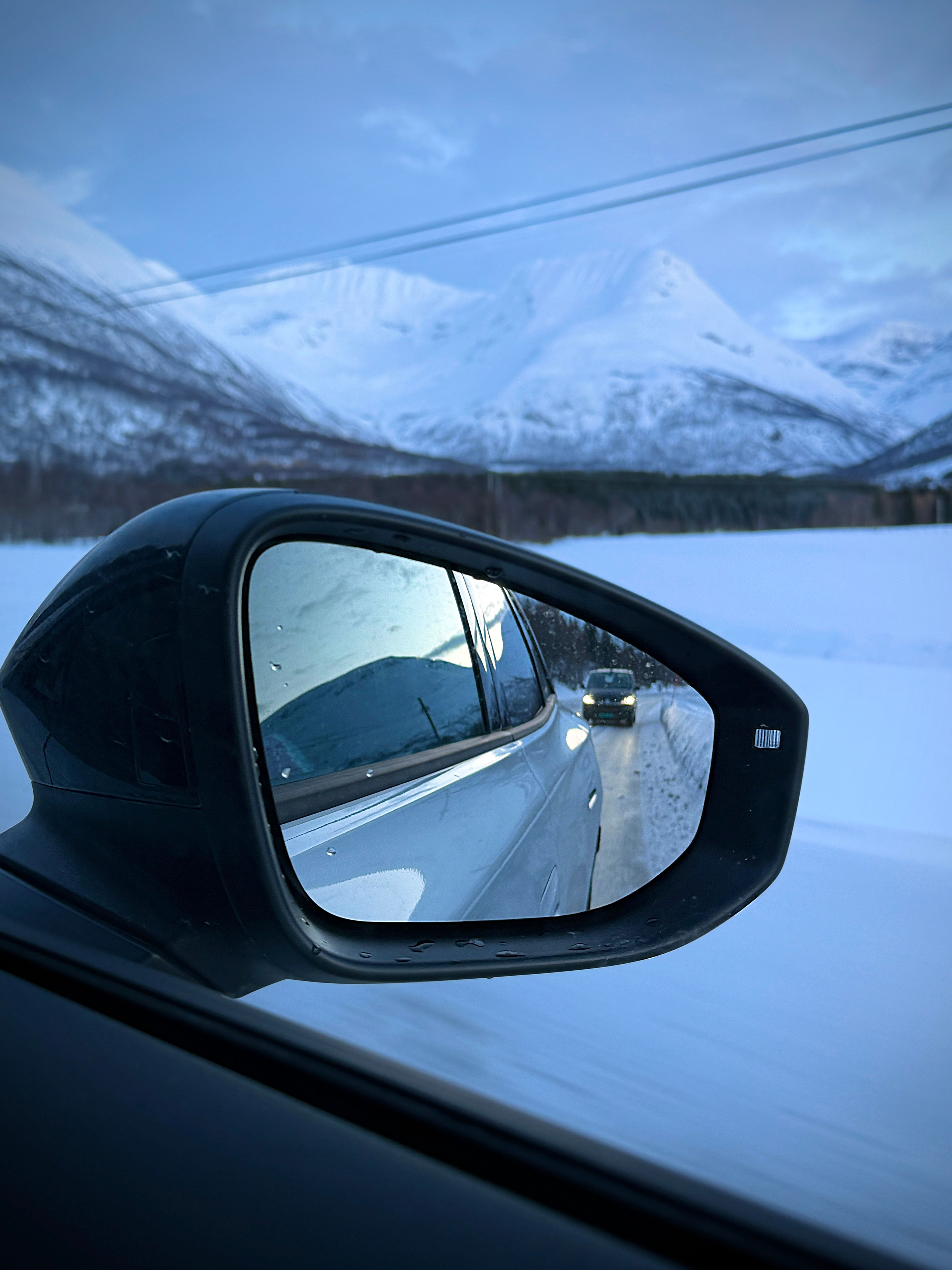 A car in a car mirror - winter driving in Norway 
