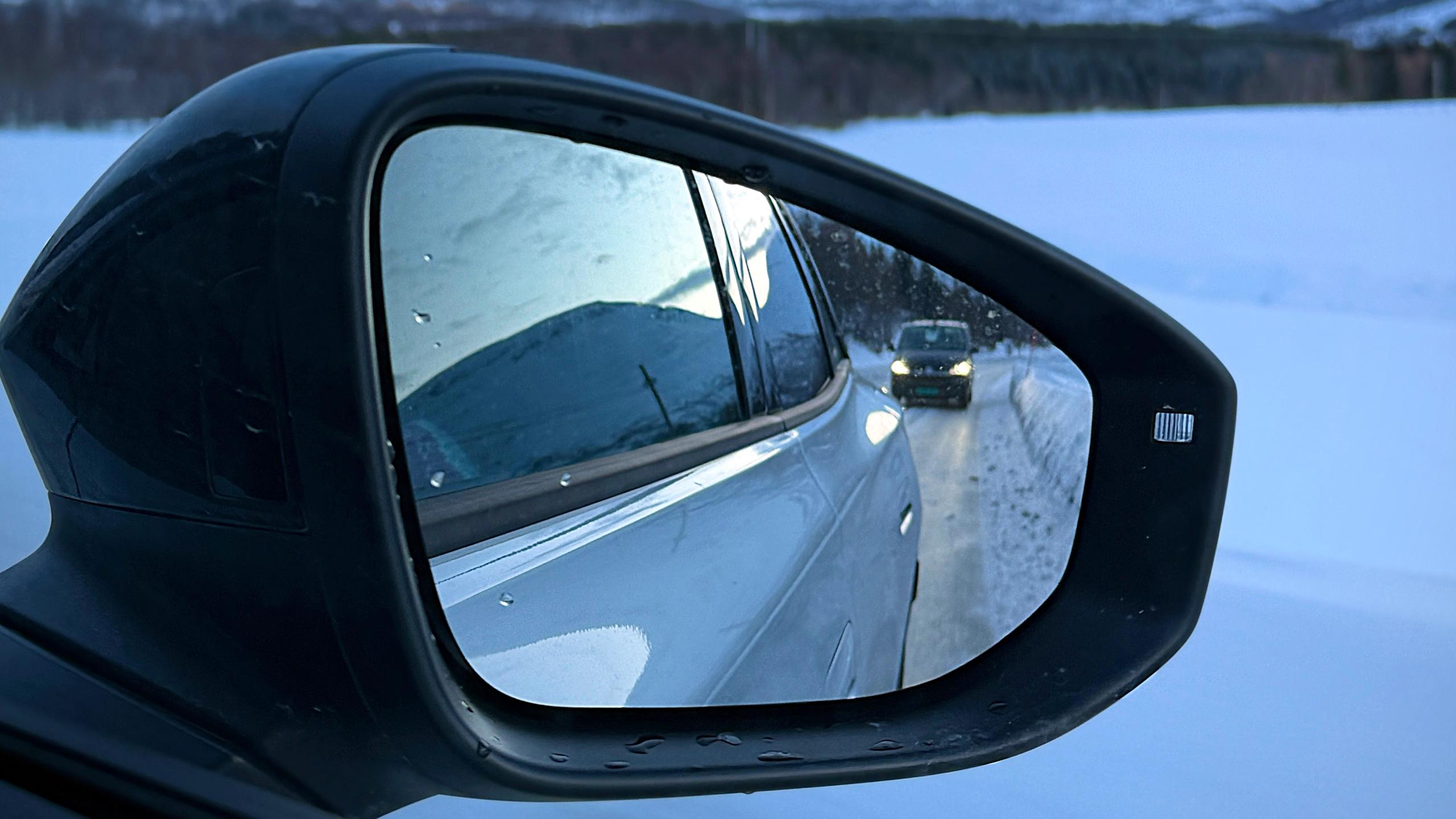 A car in a car mirror - winter driving in Norway