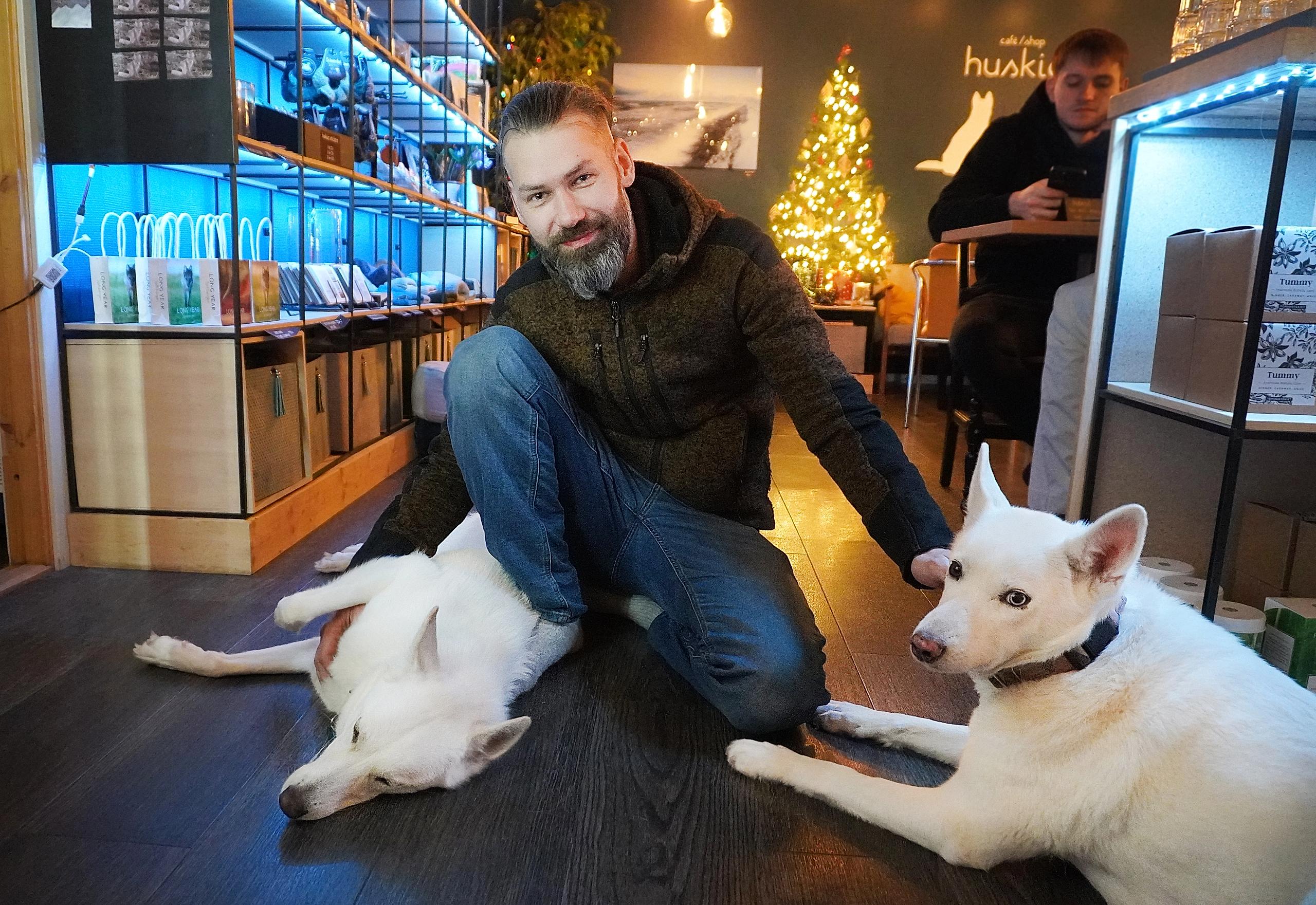 En mann med to huskyer inne på en kafe