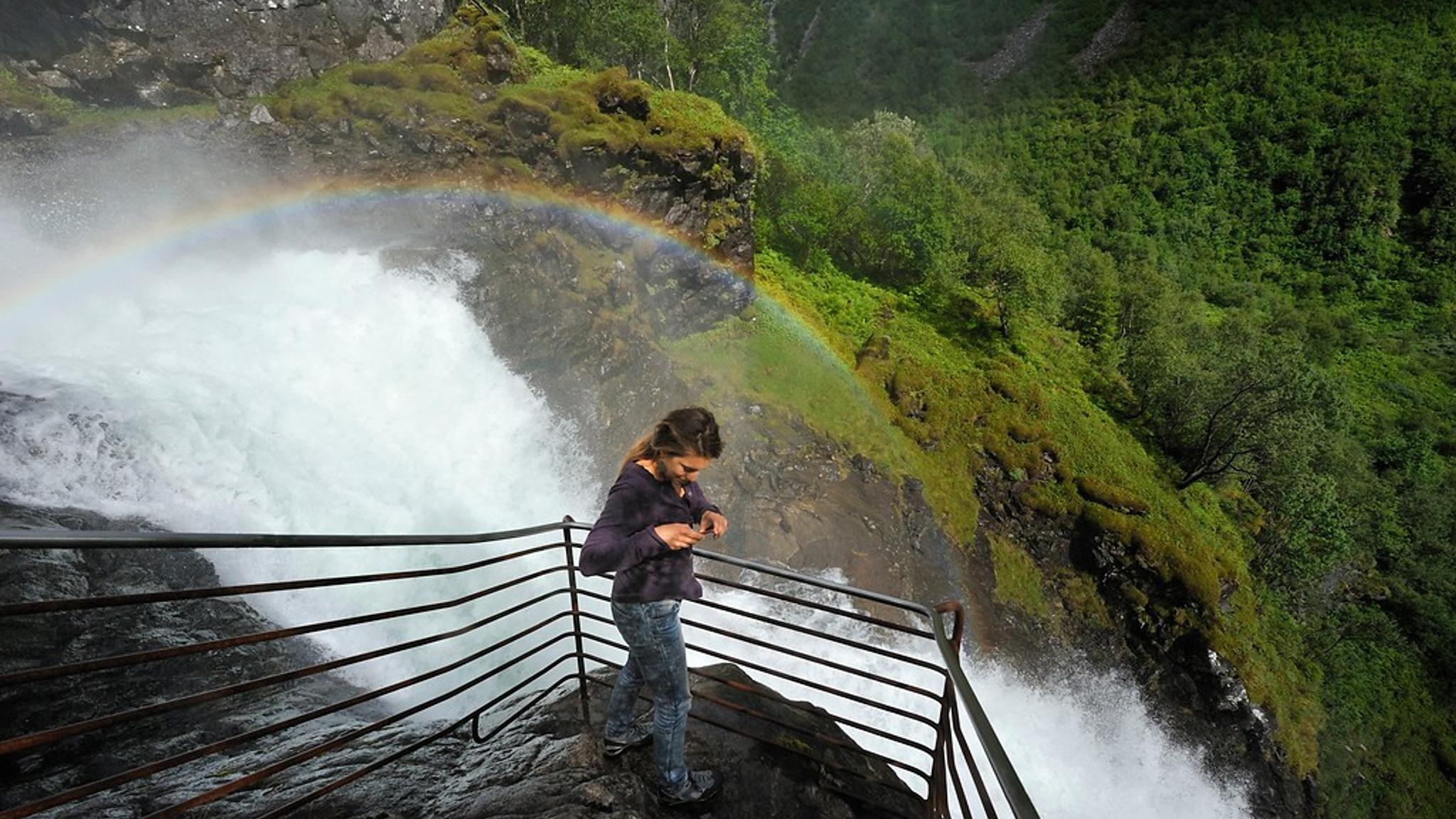 A woman looking at a waterfall.