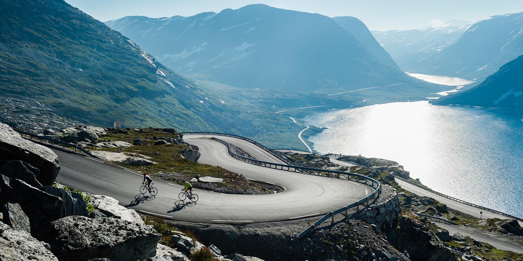 Deux cyclistes gravissant les lacets au-dessus du Geirangerfjord en Norvège des Fjords