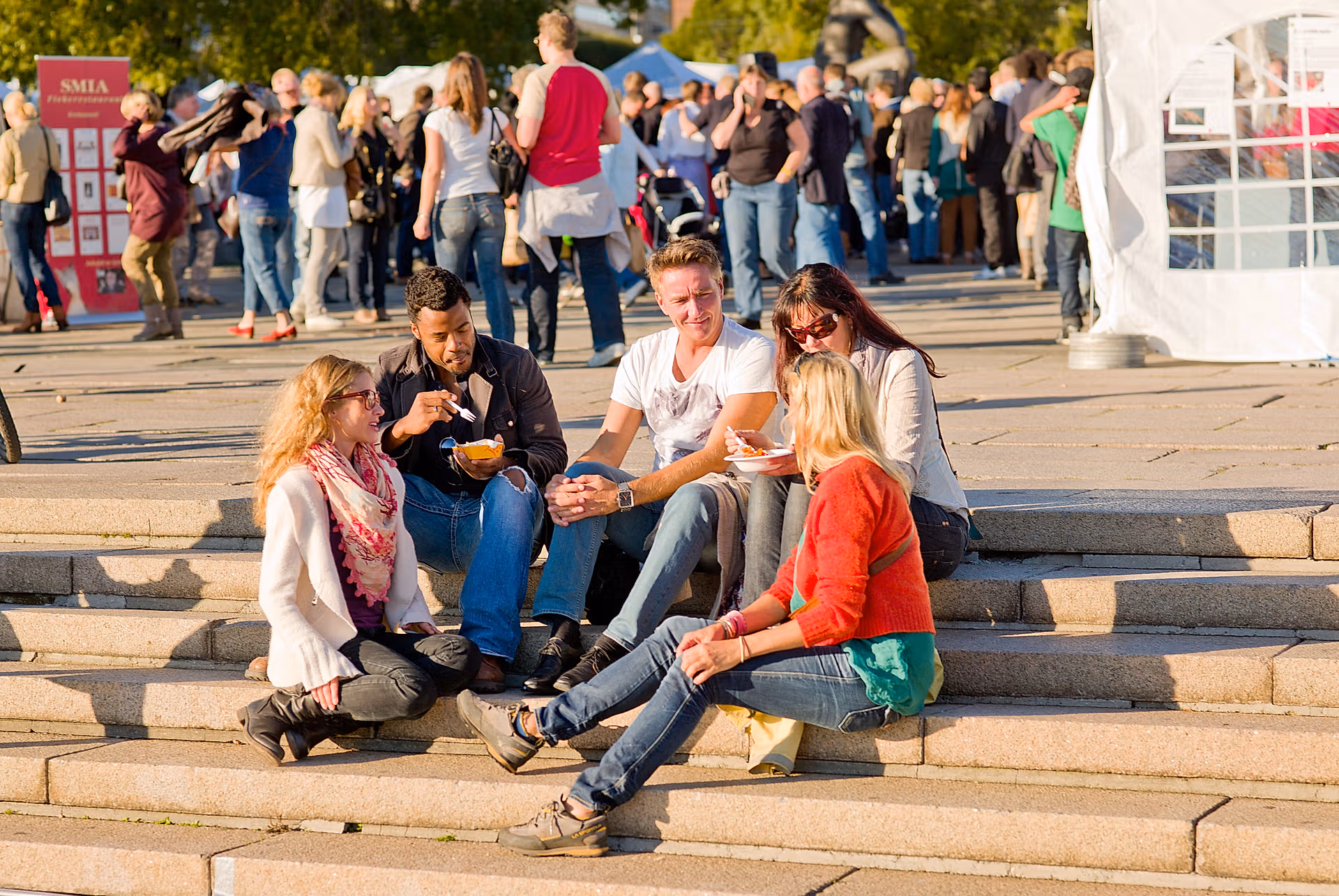 Folk som spiser mat i solen på matfestival