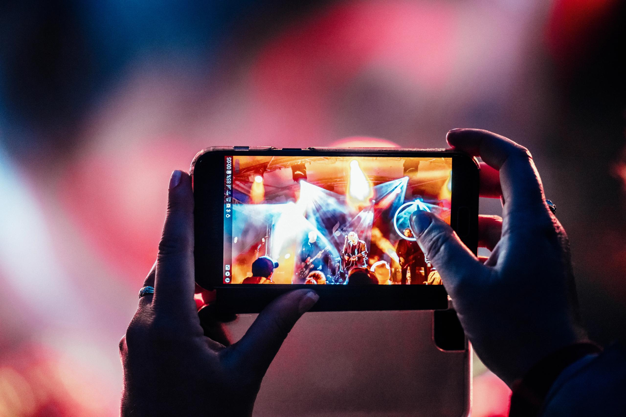 A person taking a picture of a consert.