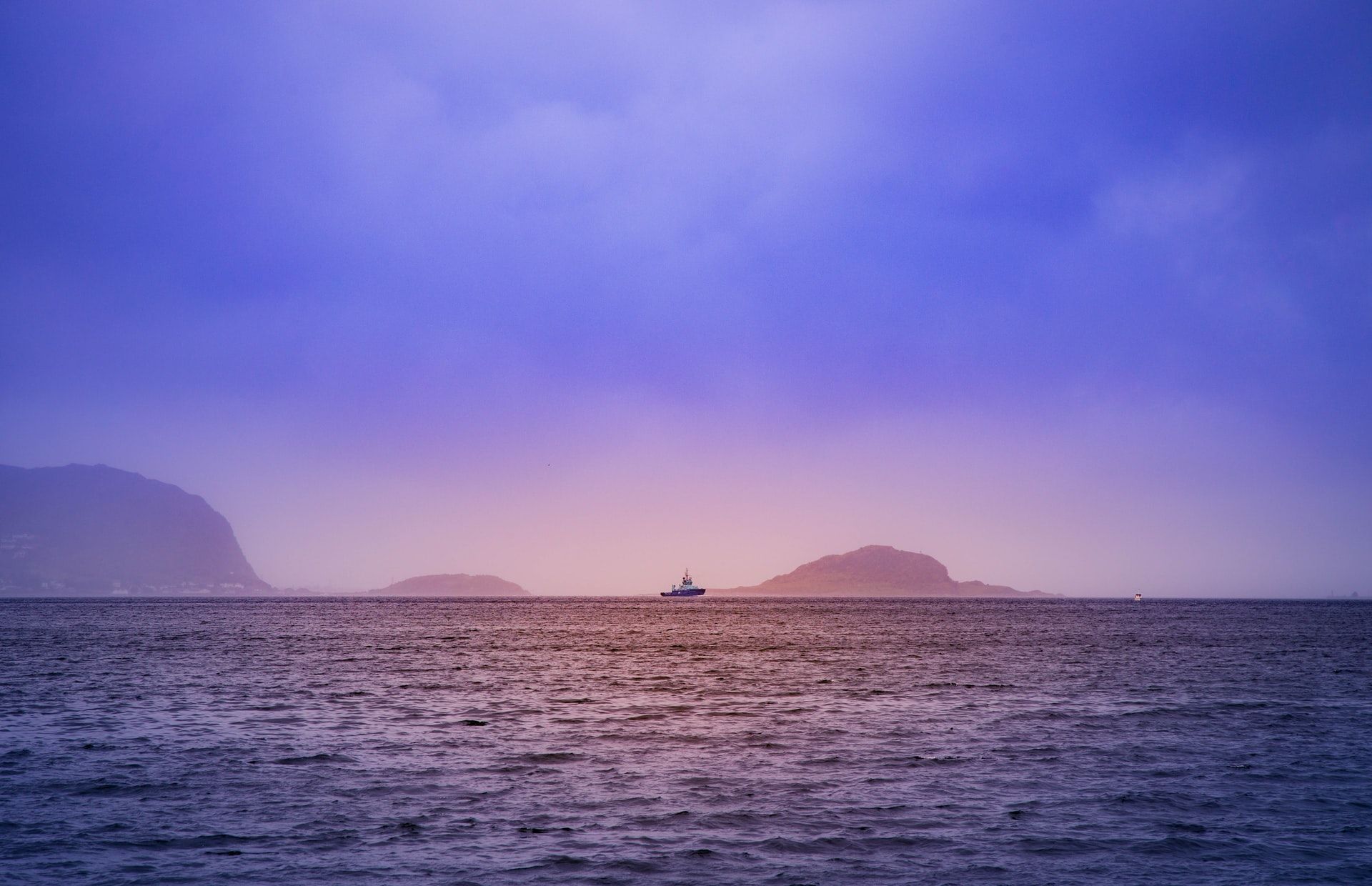 Boat in the horizon outside of Ålesund in Fjord Norway