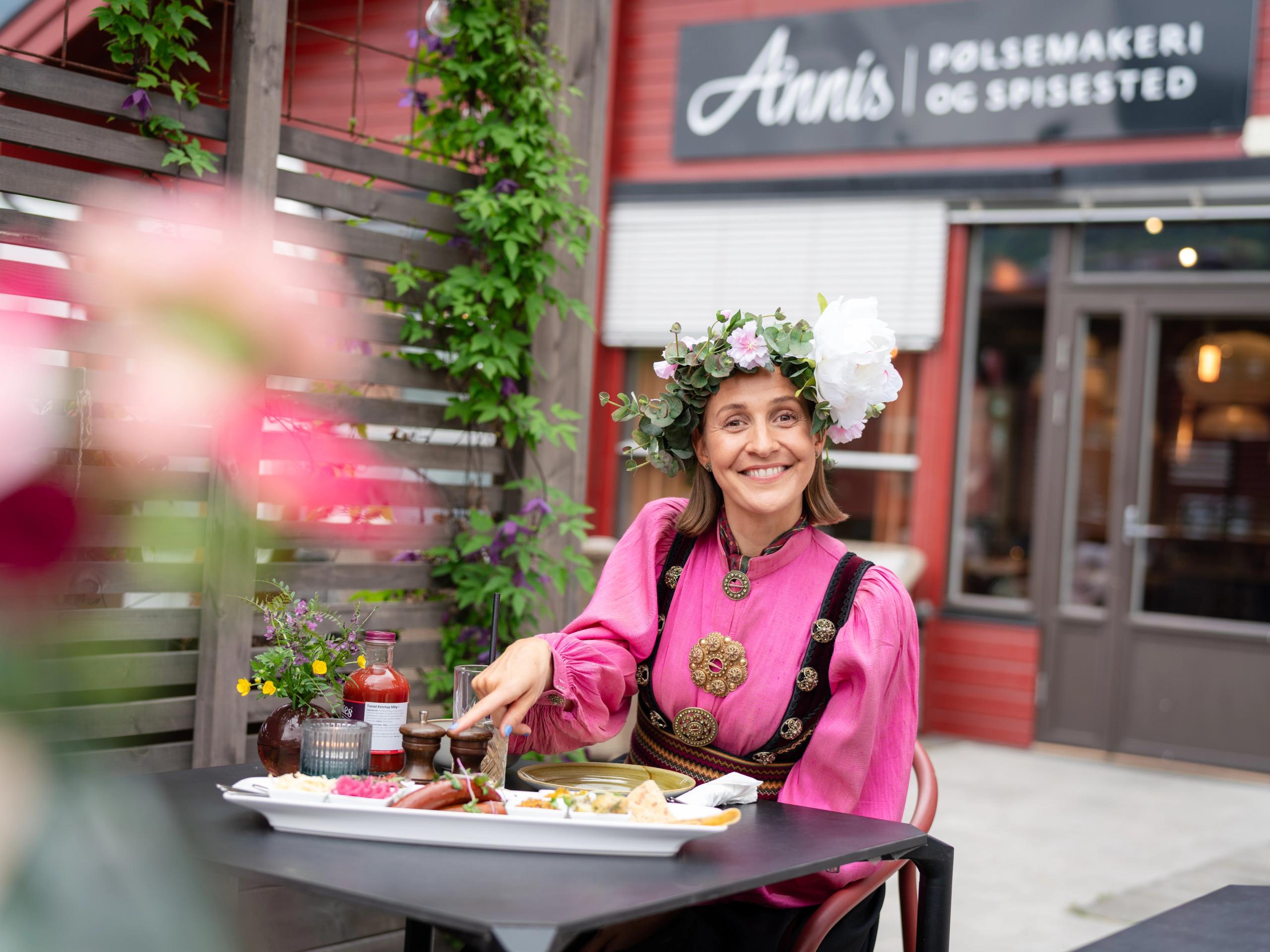 Woman eating at Annis Pølsemakeri (sausage factory) in Ringebu