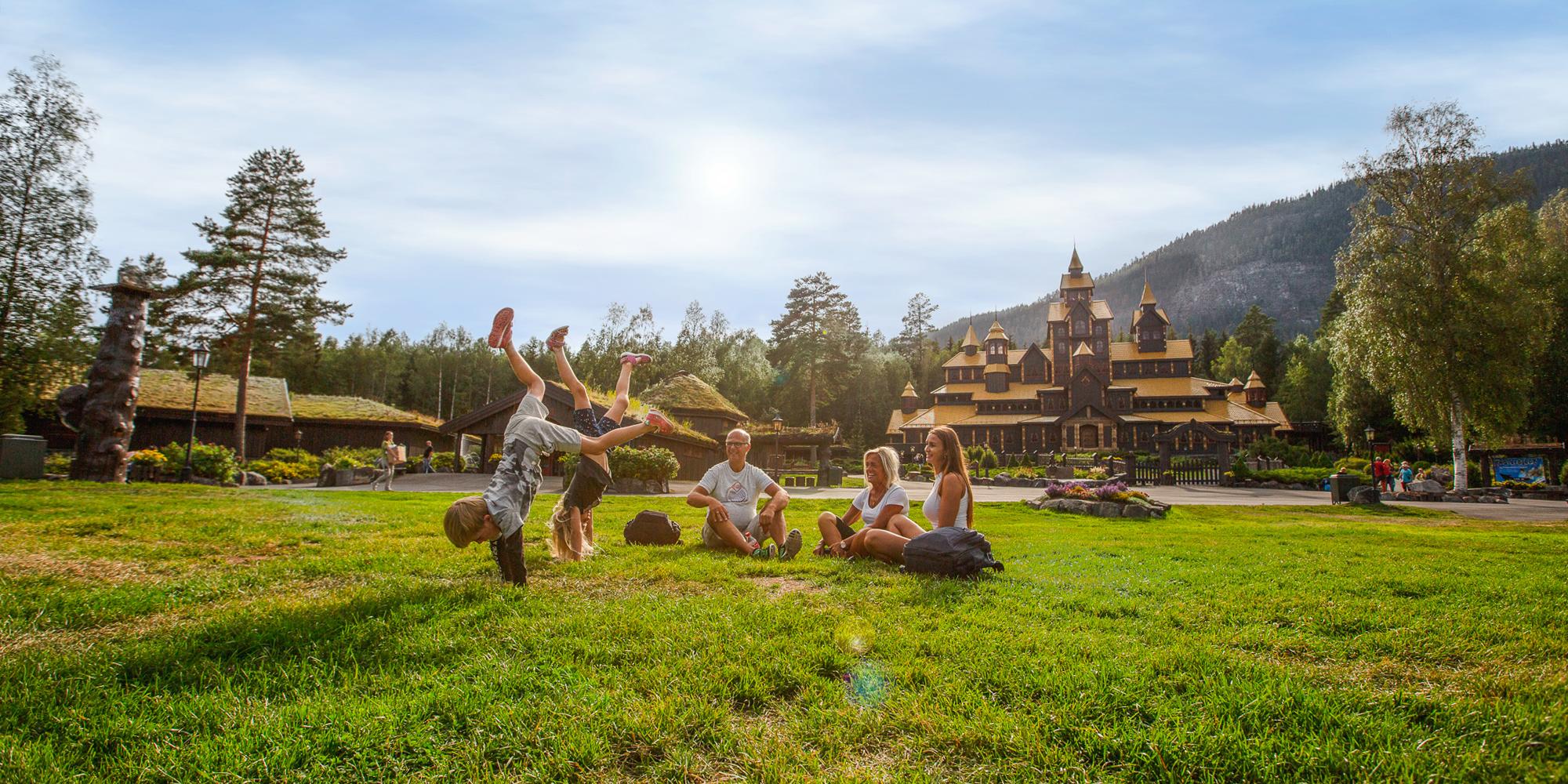 Una familia se divierte frente al castillo encantado del parque de atracciones Hunderfossen en Lillehammer, Este de Noruega.