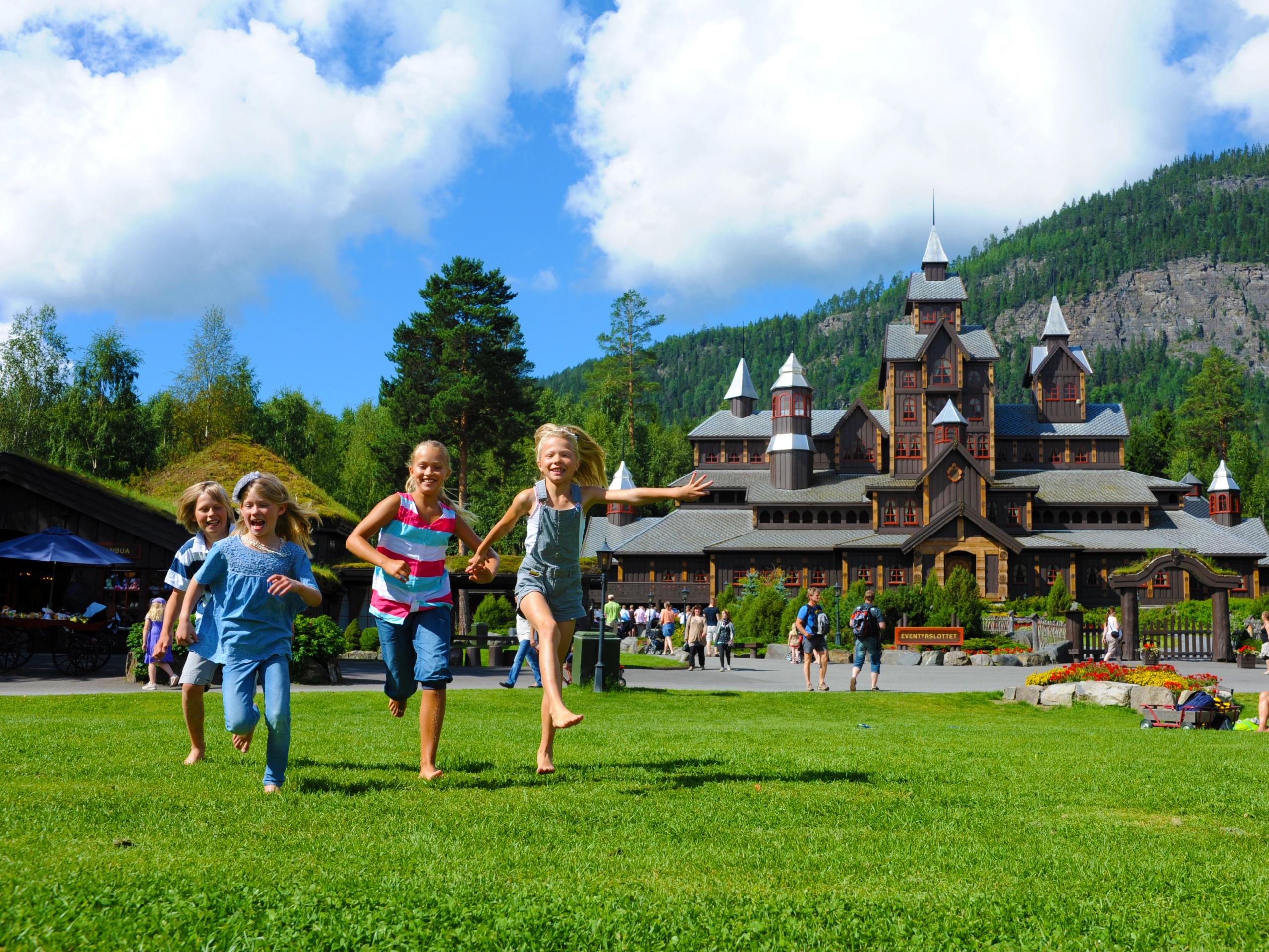 Børn løber foran eventyrslottet i Hunderfossen Familiepark i Lillehammer-området, Norge