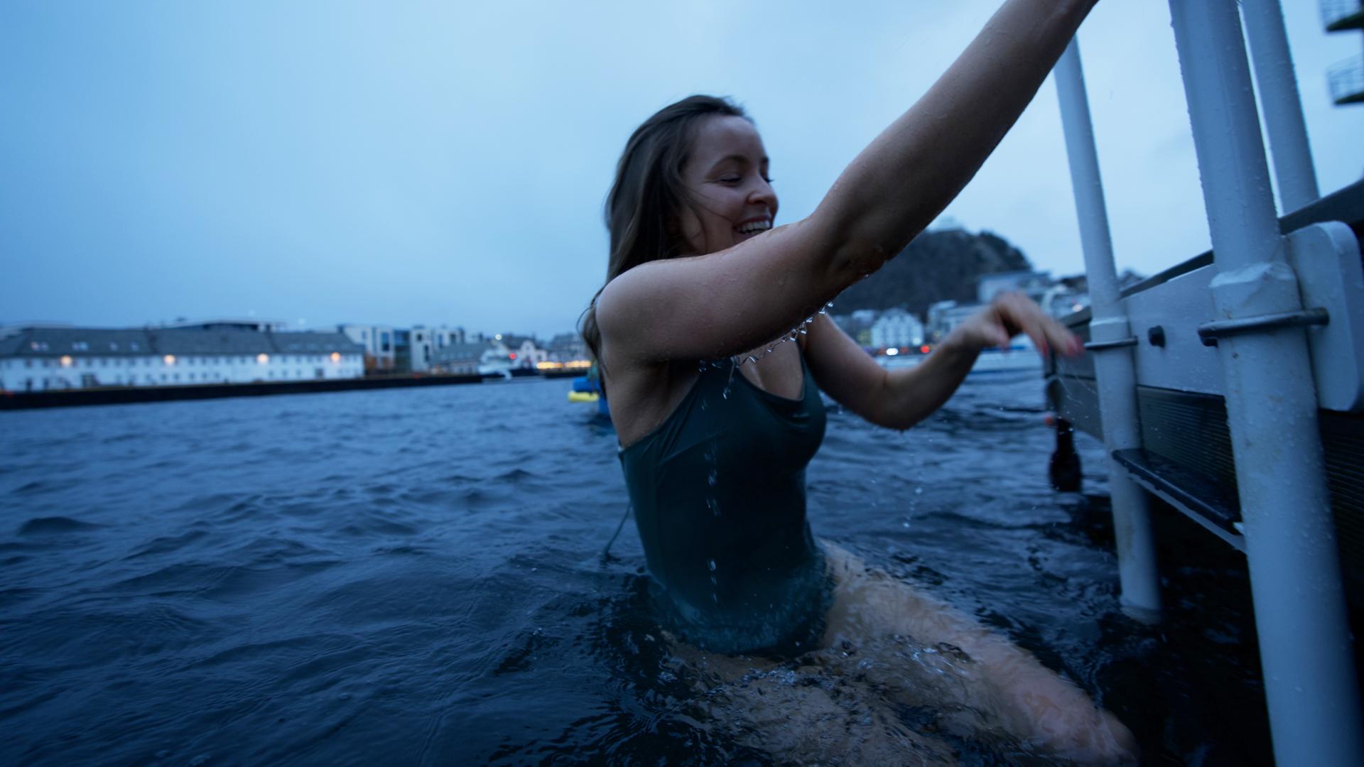 Woman ice bathing at the Svai sauna in Ålesund, Fjord Norway
