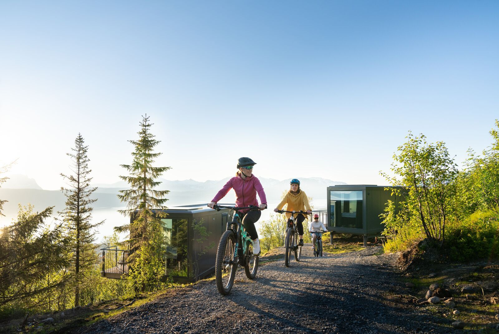 Tre kvinner på sykkeltur under midnattssola på Narvikfjellet