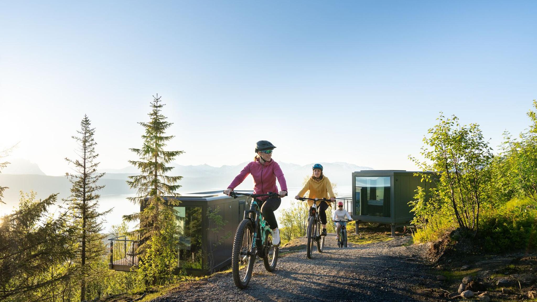 Three women biking under the midnight sun at Narvikfjellet