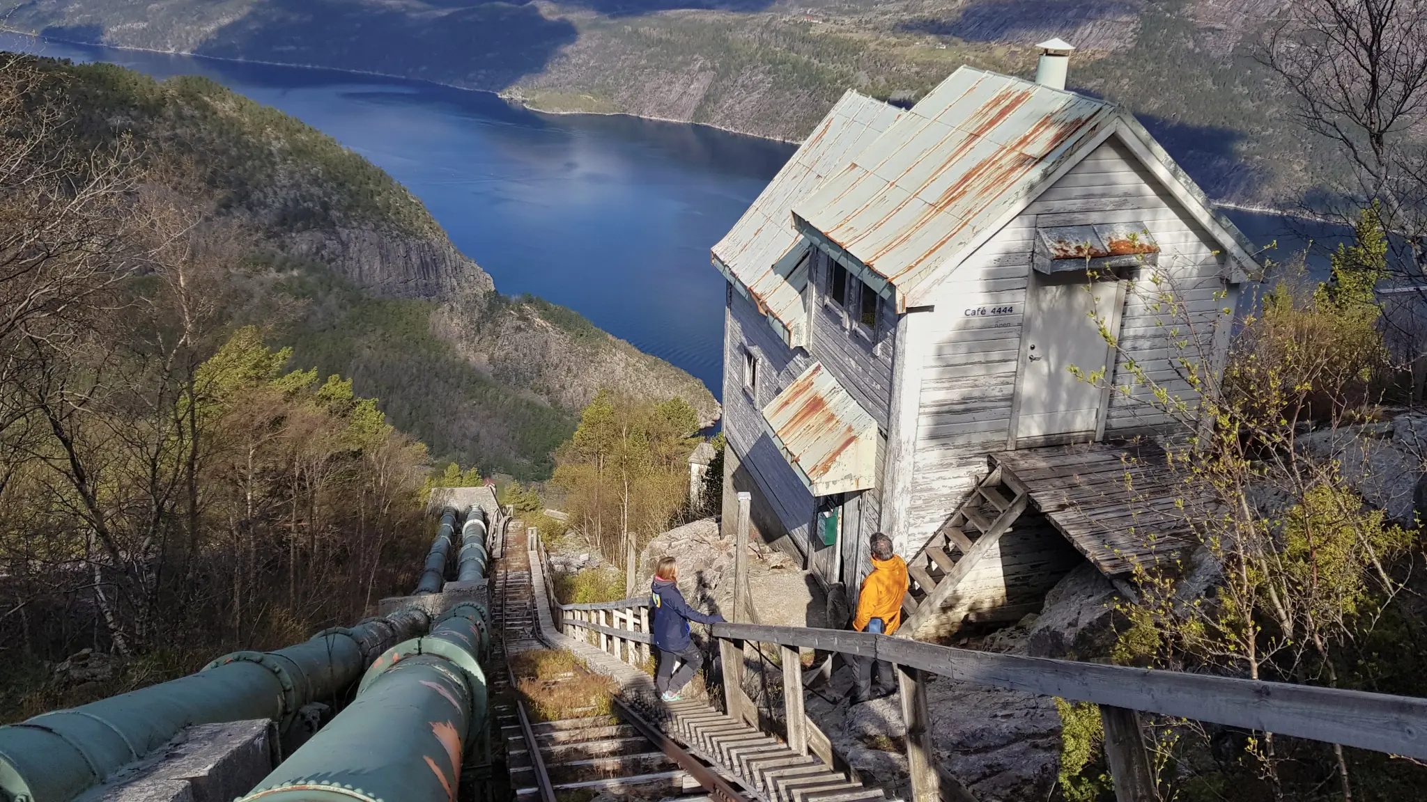 People hiking up wooden stairs to reach the top of a mountain