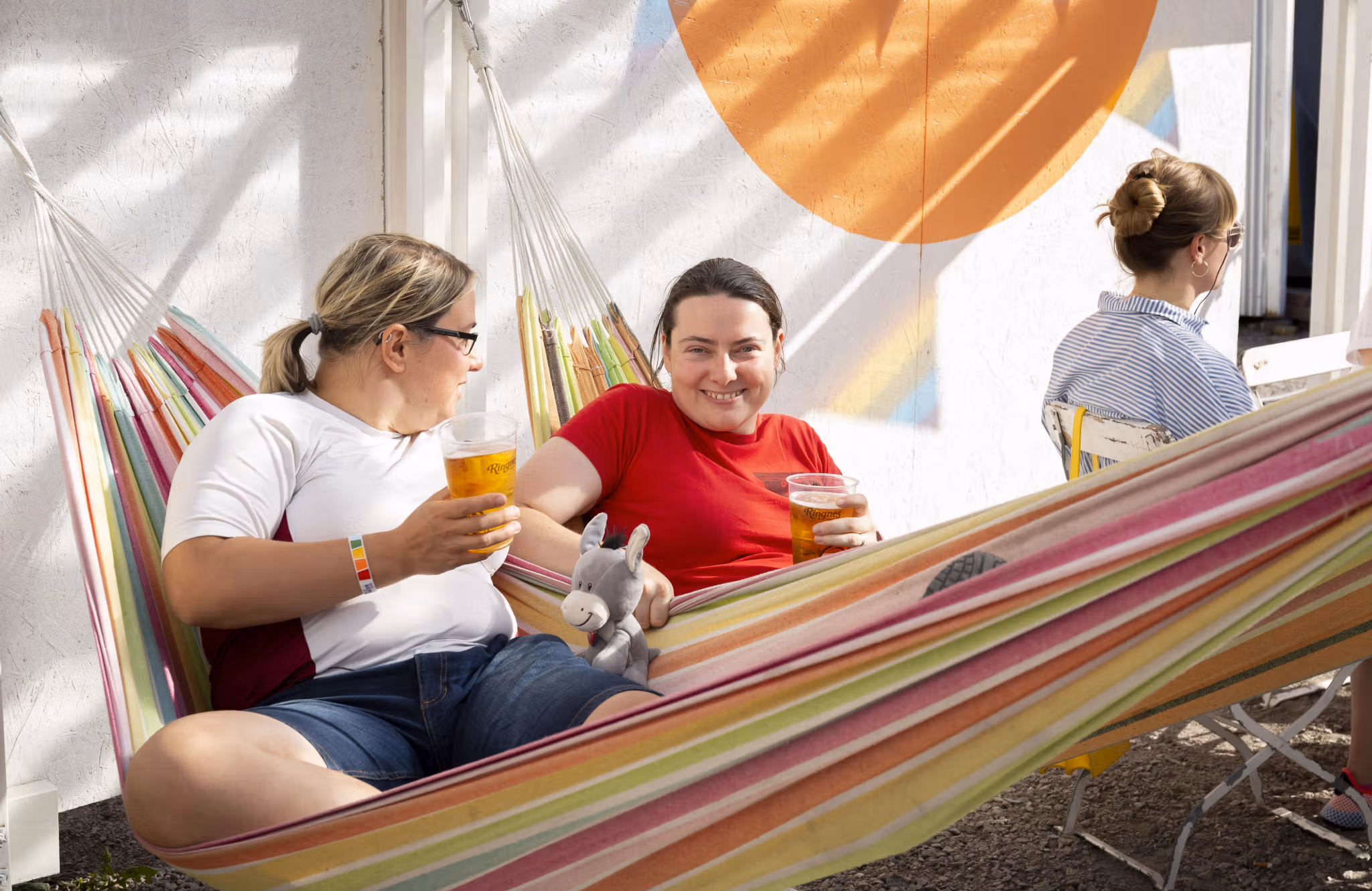 Anna and Klára enjoying a drink in a hammock at Oslo Pride