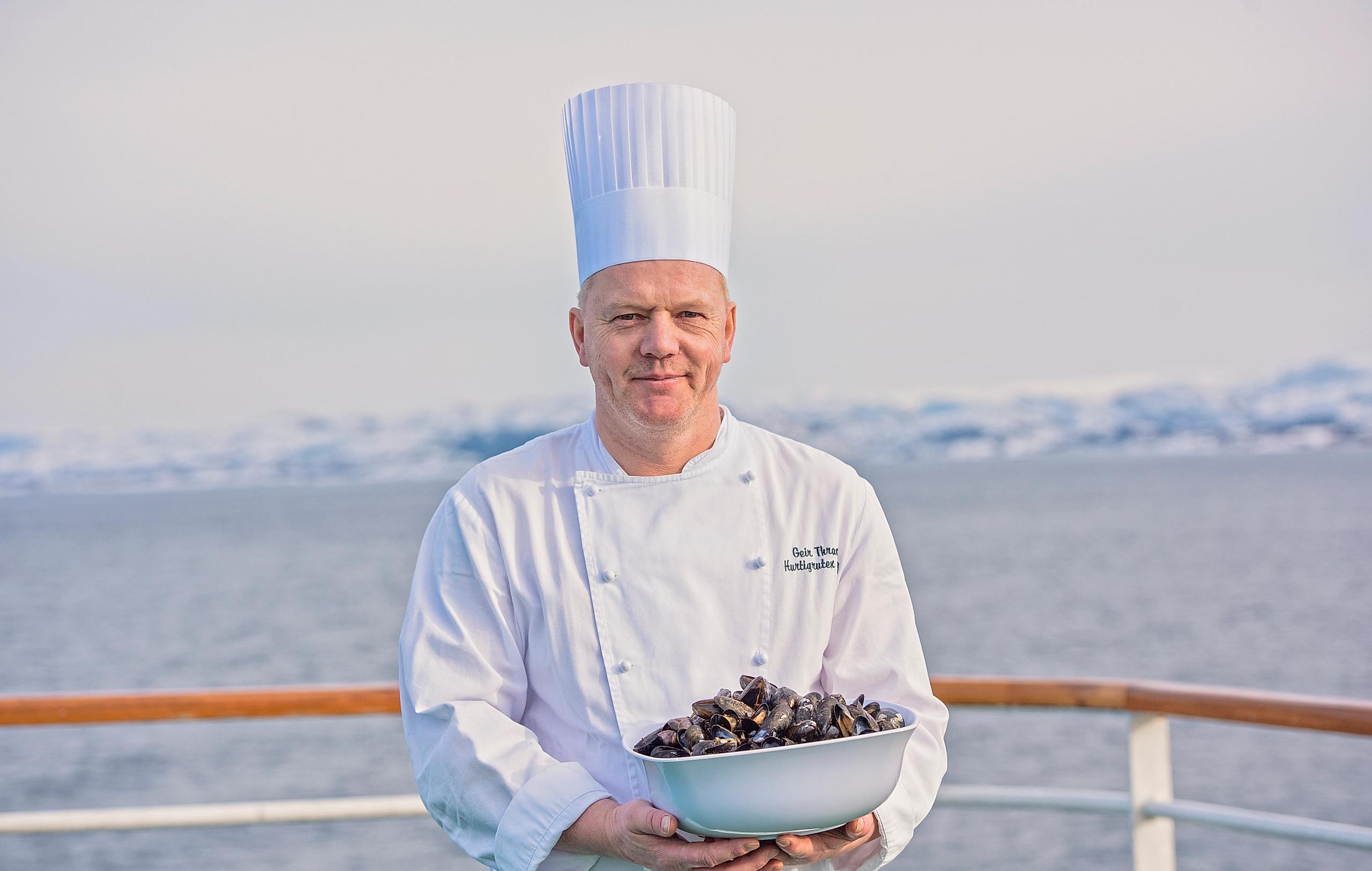 En kokk som holder blåskjell på dekk på Hurtigruten