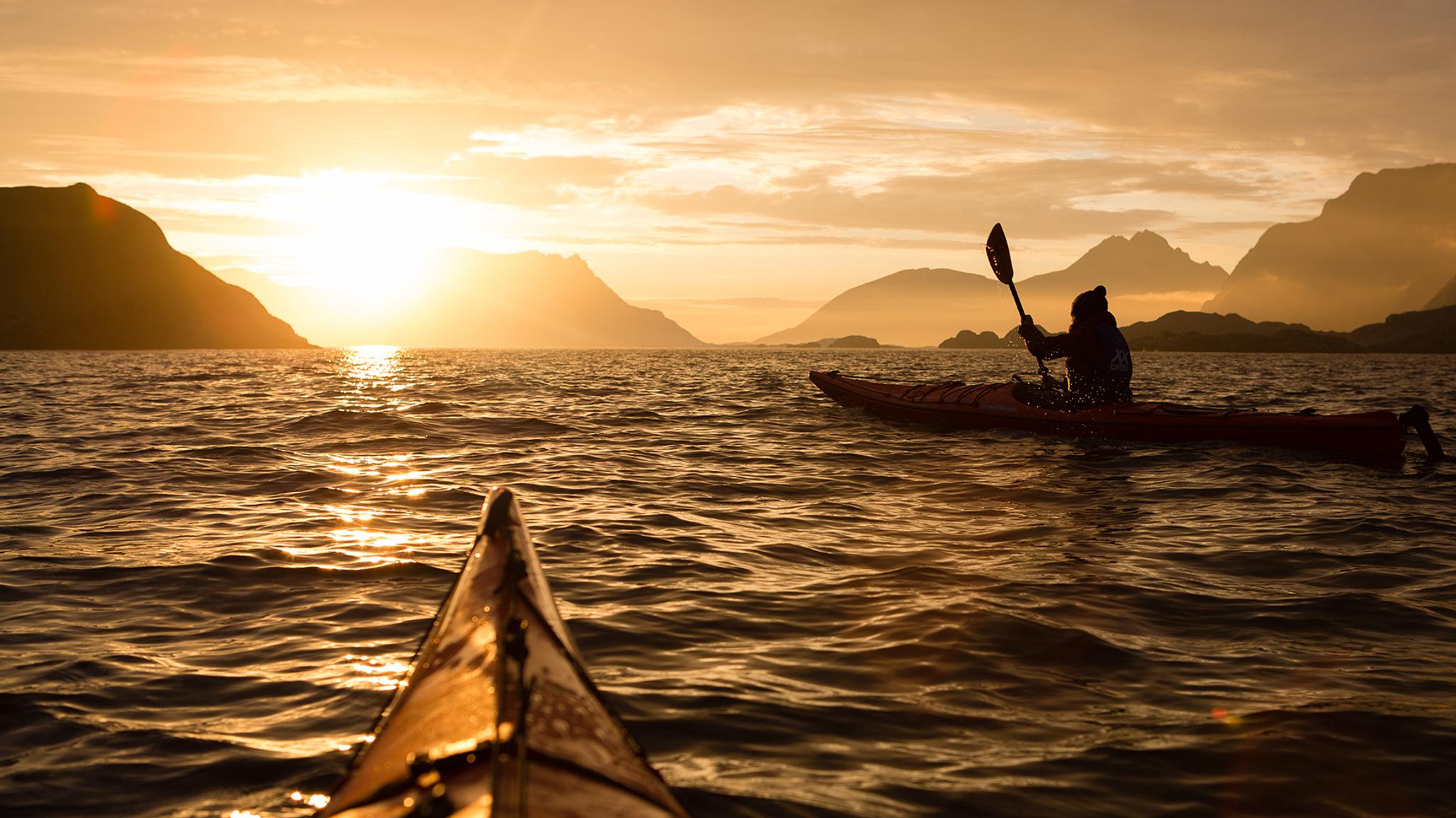 Kajakkpadling under midnattssolen i Lofoten i Nord-Norge