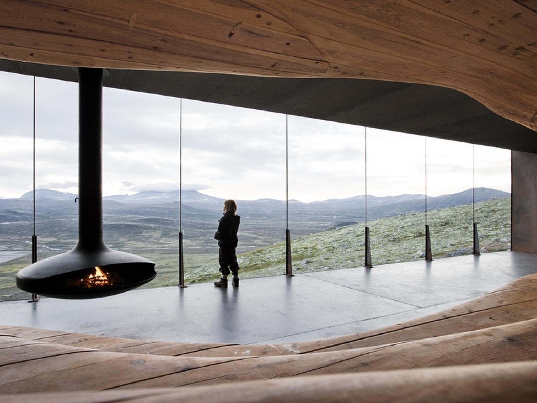 A person looking at the view from inside the Viewpoint Snøhetta in Hjerkinn.