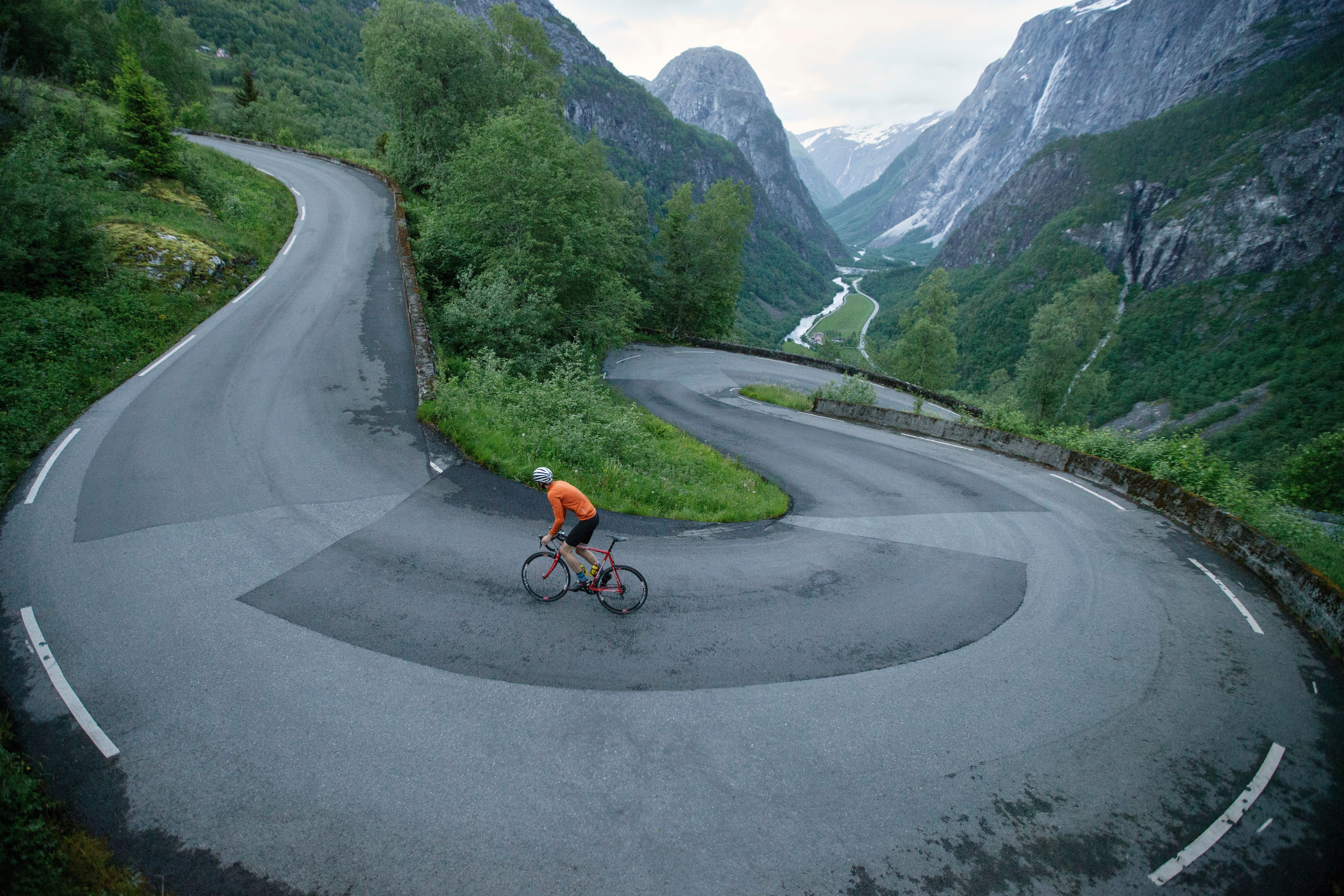 En person cyklar uppför Stalheimskleiva, en av Norges 5 bästa cykelleder i fjällmiljö, i Voss i regionen Fjord Norge (Vestlandet)